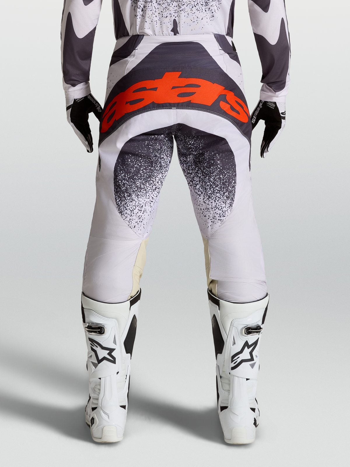Alpinestars Techstar Swan bukser, motocross-racerbukser til herrer, lys lilla og mørkegrå, rød logo på sædet, set bagfra på model