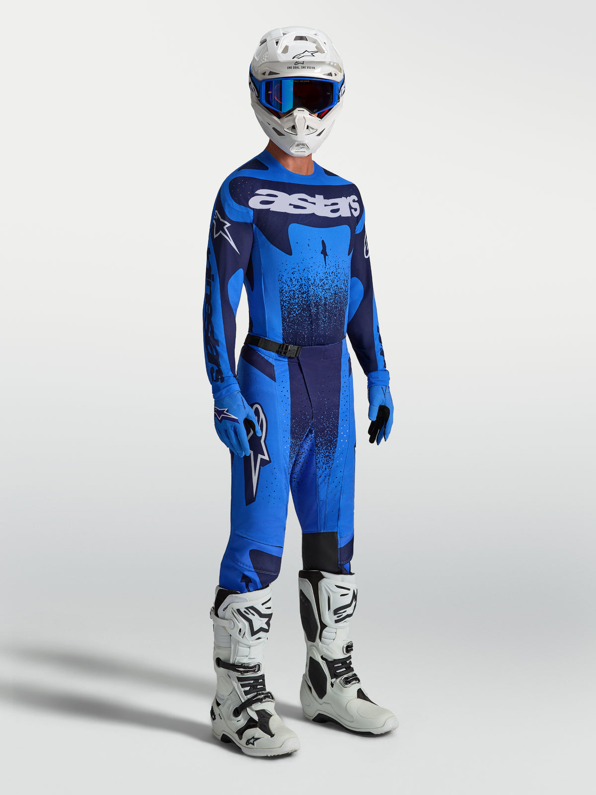 Alpinestars Techstar Swan Bukser, herre-motocrossudstyr i blå og navy, vist med matchende trøje og hvide racerstøvler.