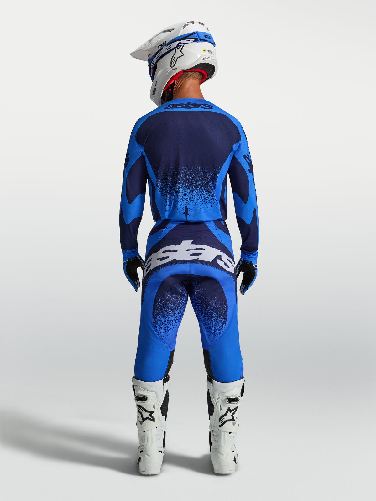 Alpinestars Techstar Swan bukser, motocrossbukser til herrer, blå og mørkeblå, set bagfra med hvide støvler.