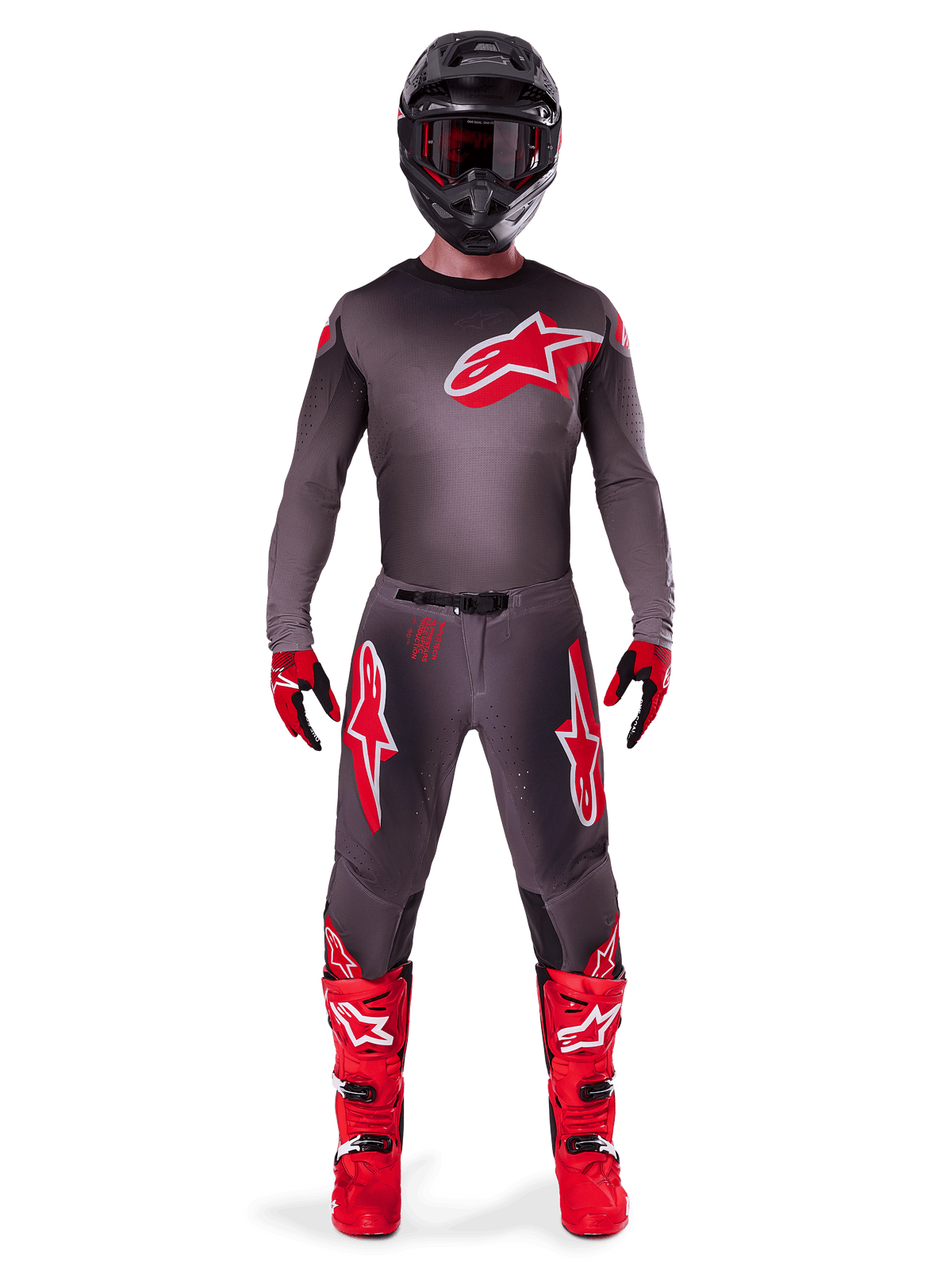 Motocross-kører iført komplet Alpinestars 2025 Supertech Lipan gear-sæt, Smoke Bright Red, med mørkegrå trøje og bukser med fremtrædende røde logoer, sort hjelm med briller, røde og sorte handsker og klare røde motocross-støvler, koordineret professionelt raceroutfit.