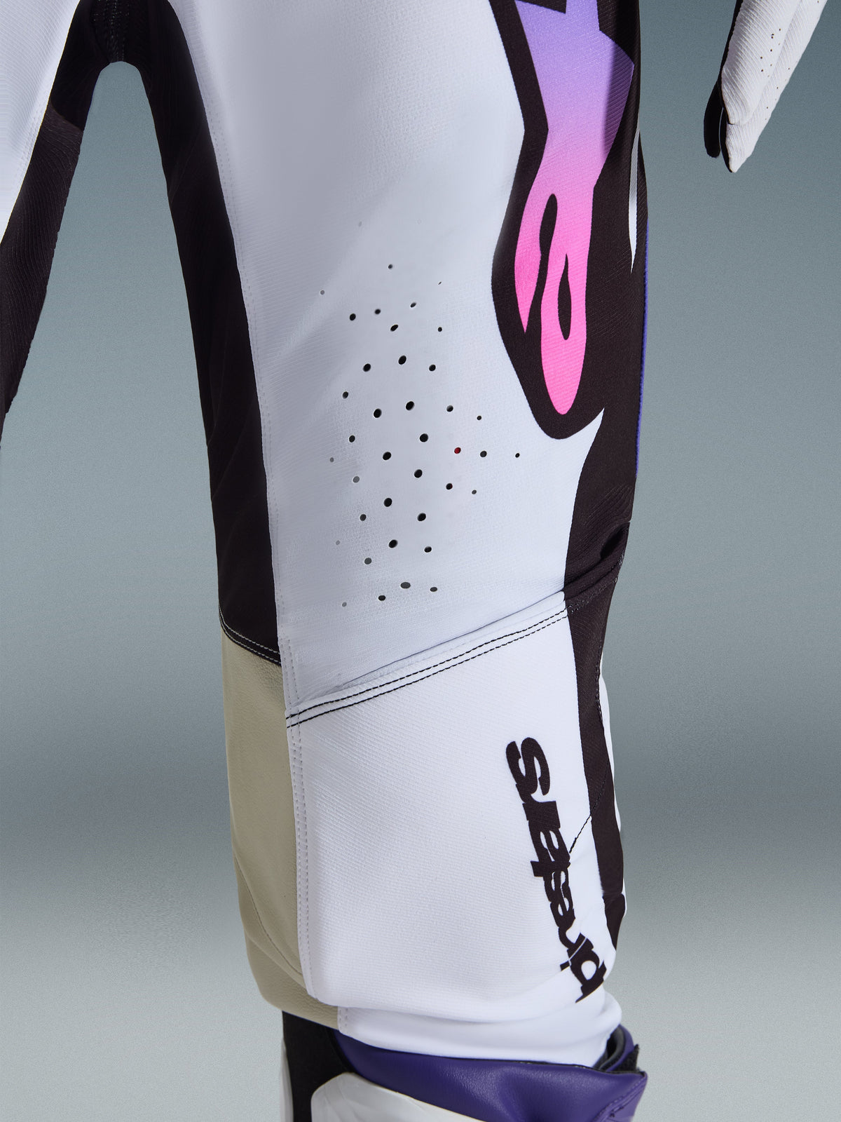 Alpinestars 2026 Supertech AFD Vista bukser, motocross-bukser, hvid, lilla og sort, nærbillede der viser laserskårne ventilationshuller, lodret Alpinestars-logo og sandfarvede indvendige knæpaneler, performance-racingudstyr