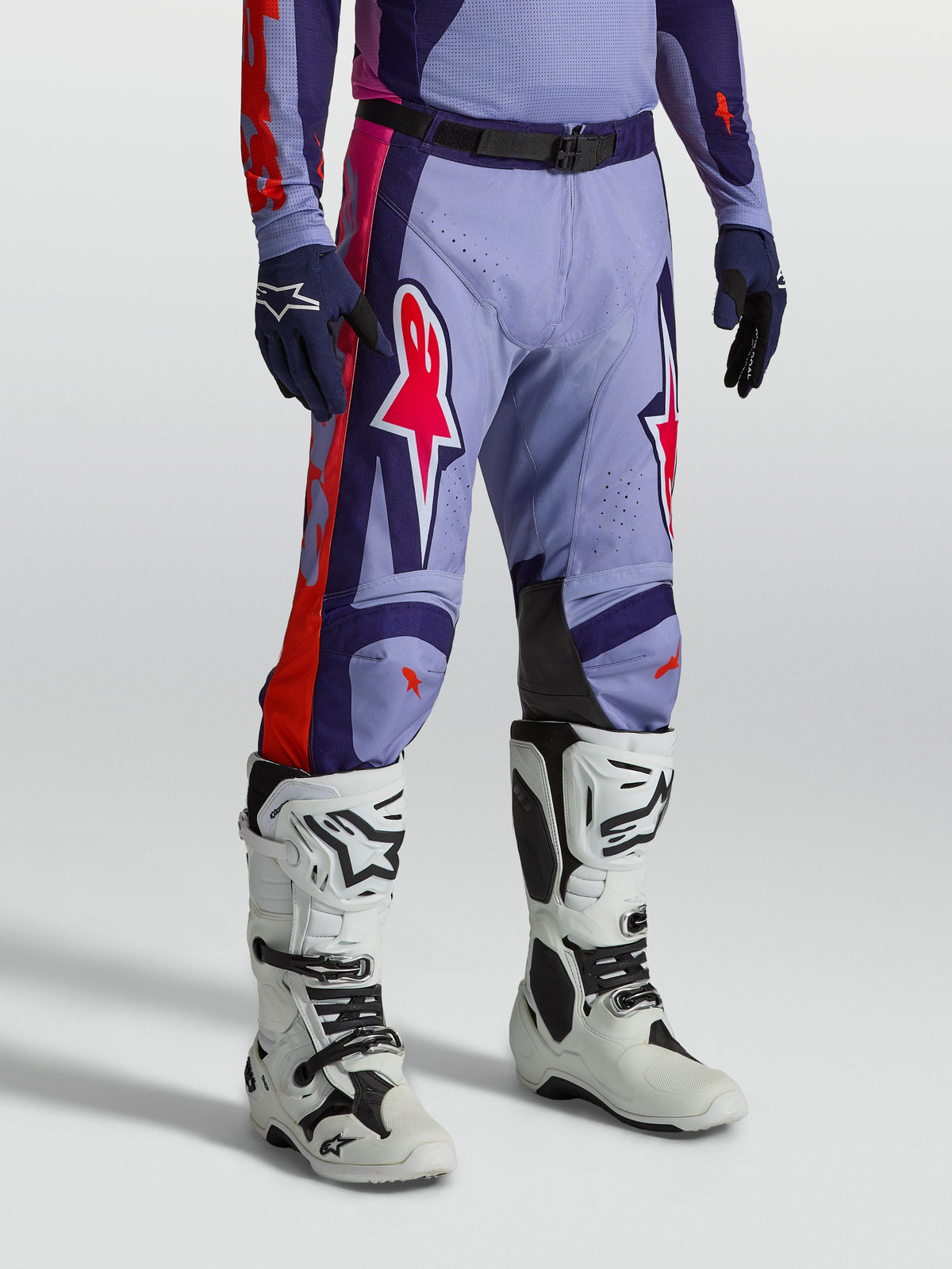 Alpinestars Racer Air Hunt bukser, ventileret lilla og pink motocrossudstyr vist på model med hvide støvler.