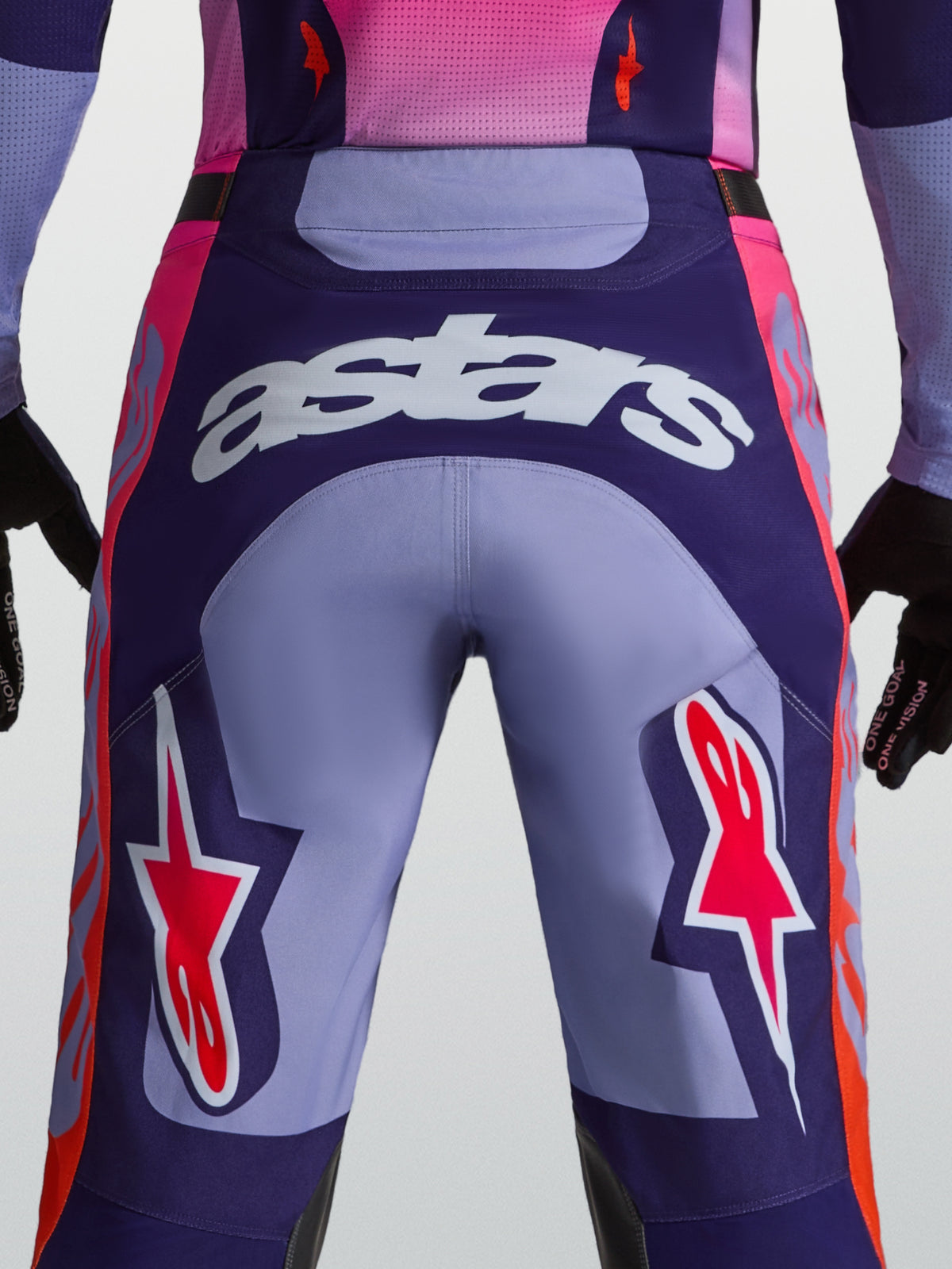 Alpinestars Racer Air Hunt bukser, lilla og pink motocrossbukser til herrer, set bagfra på model med hvidt astars-logo og ventileret konstruktion til terrænkørsel.