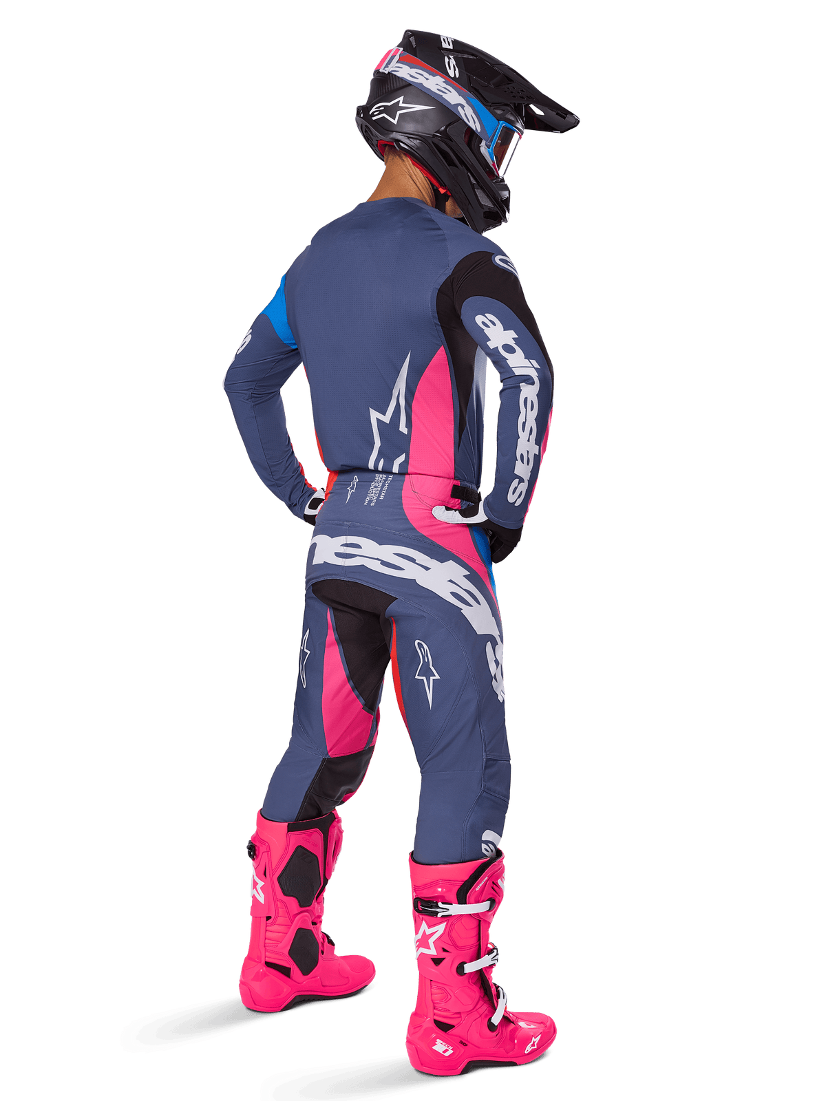 Motocrossrytter set bagfra, Alpinestars 2025 Techstar Dreem bukser, gråblåt og magenta pink design med sorte detaljer, matchende trøje og stærke pink støvler, atletisk race-pasform til off-road performance