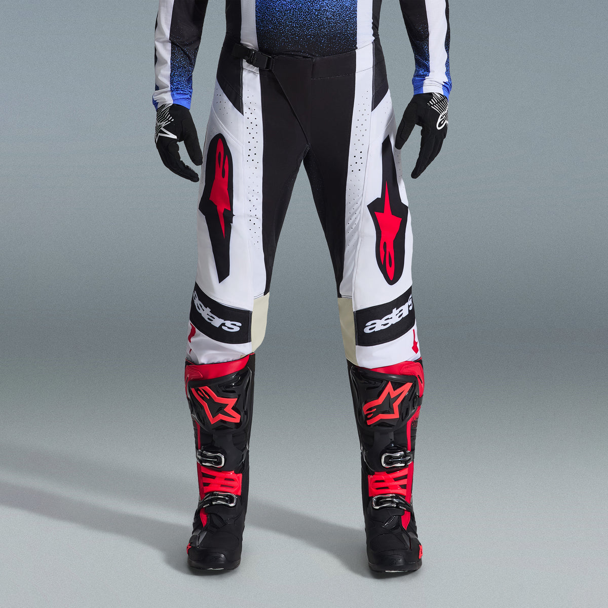 Alpinestars 2026 Techstar Knif-udstyrssæt, motocross-udstyr, sorte og hvide bukser med store røde stjernelogoer, båret med sorte og røde racingstøvler og sorte handsker, professionel atletisk pasform til off-road-performance
