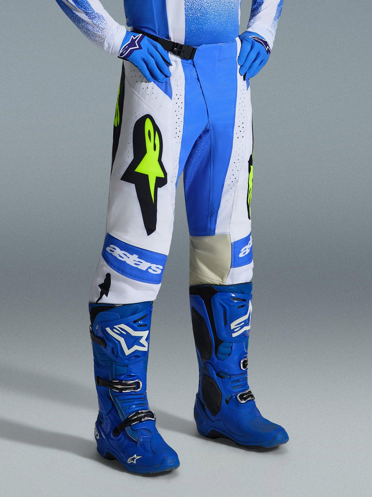 Alpinestars 2026 Techstar Knif bukser, motocross-bukser, Ucla blå, sort og gul fluo, bæres med matchende blå motocross-støvler og -handsker, med hvide paneler, store gule fluo-stjernelogoer og atletisk off-road-design