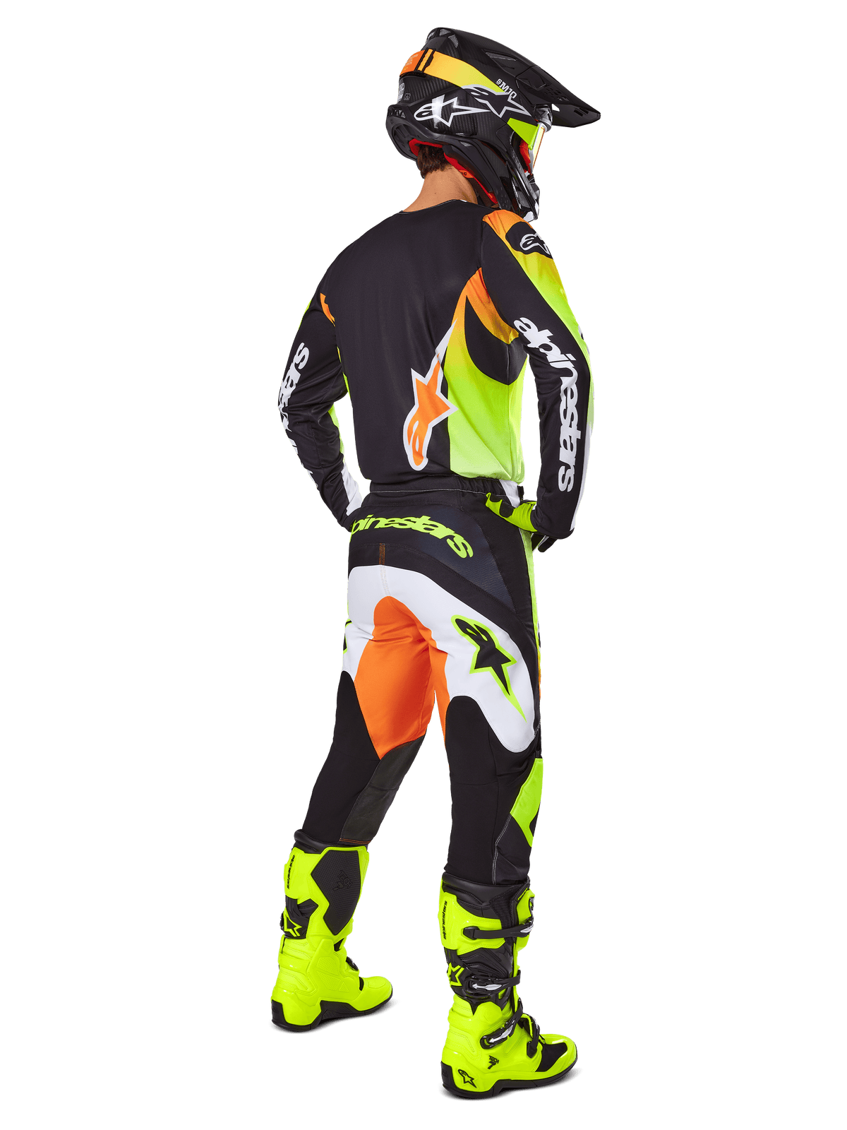 Motocrossrytter set bagfra iført Alpinestars 2025 Fluid Wurx-udstyrssæt, sort trøje med gule og orange detaljer, matchende sorte bukser med hvide og orange paneler, gule støvler og en sort hjelm, komplet off-road raceroutfit