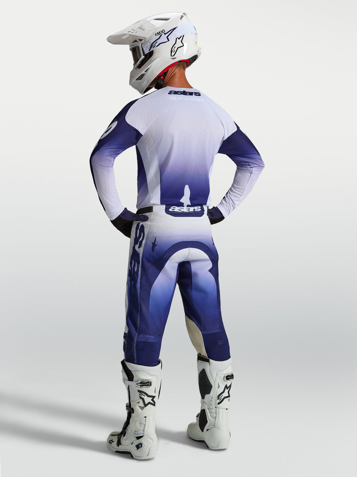 Alpinestars Racer Air Amber bukser, blå og hvide perforerede motocrossbukser til herre, set bagfra på kører med hvide støvler