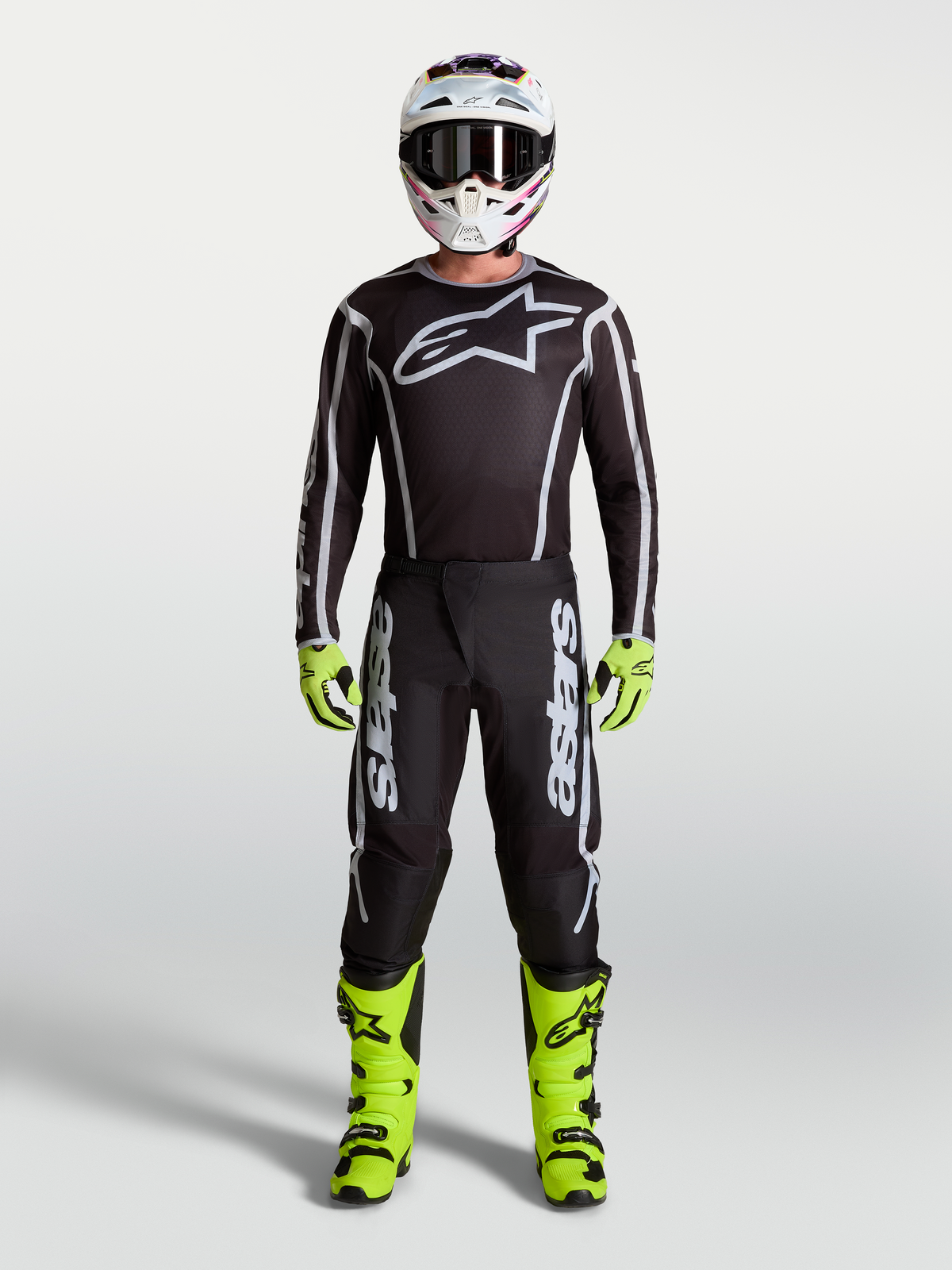 Alpinestars Fluid Apex V2 bukser i sort og sølv, herre-motocrossudstyr med neongule støvler, hjelm og racer-trøje.