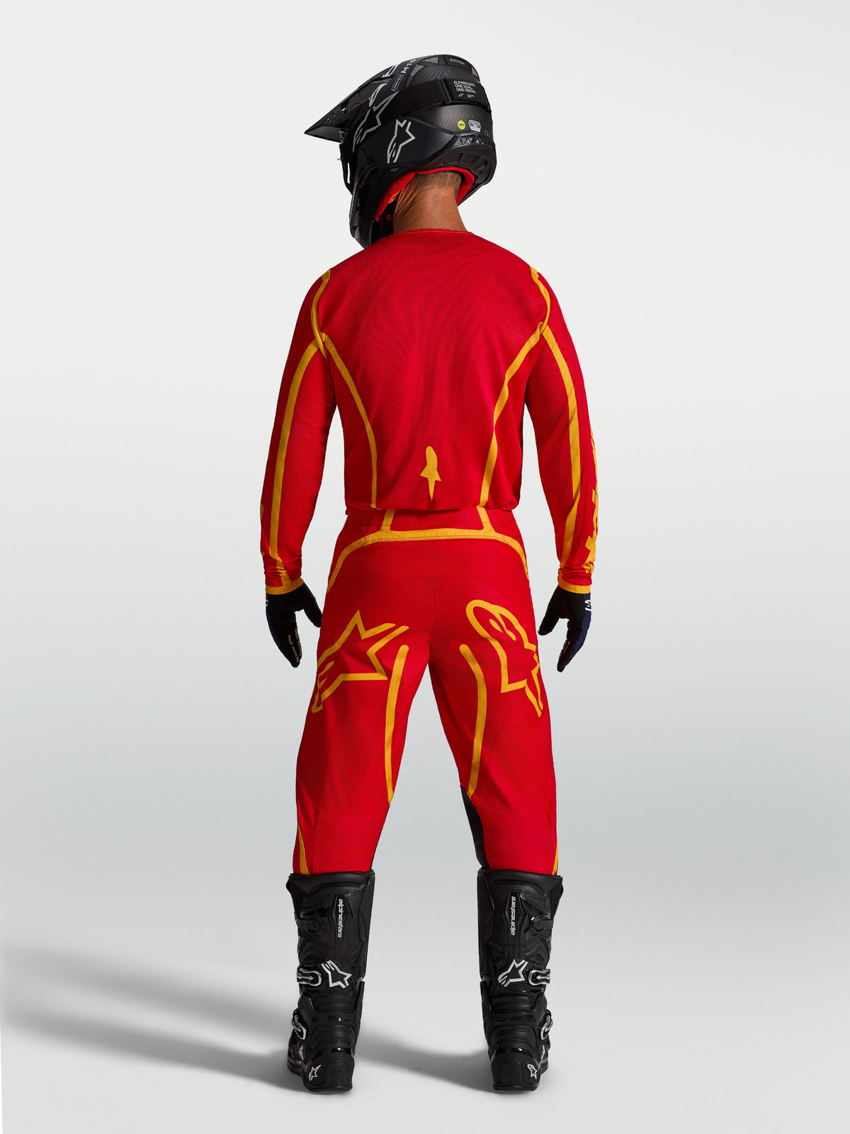 Alpinestars Fluid Apex V2 Bukser, motocrossbukser i rød og guld med forstærket sæde og sportspasform, set bagfra.