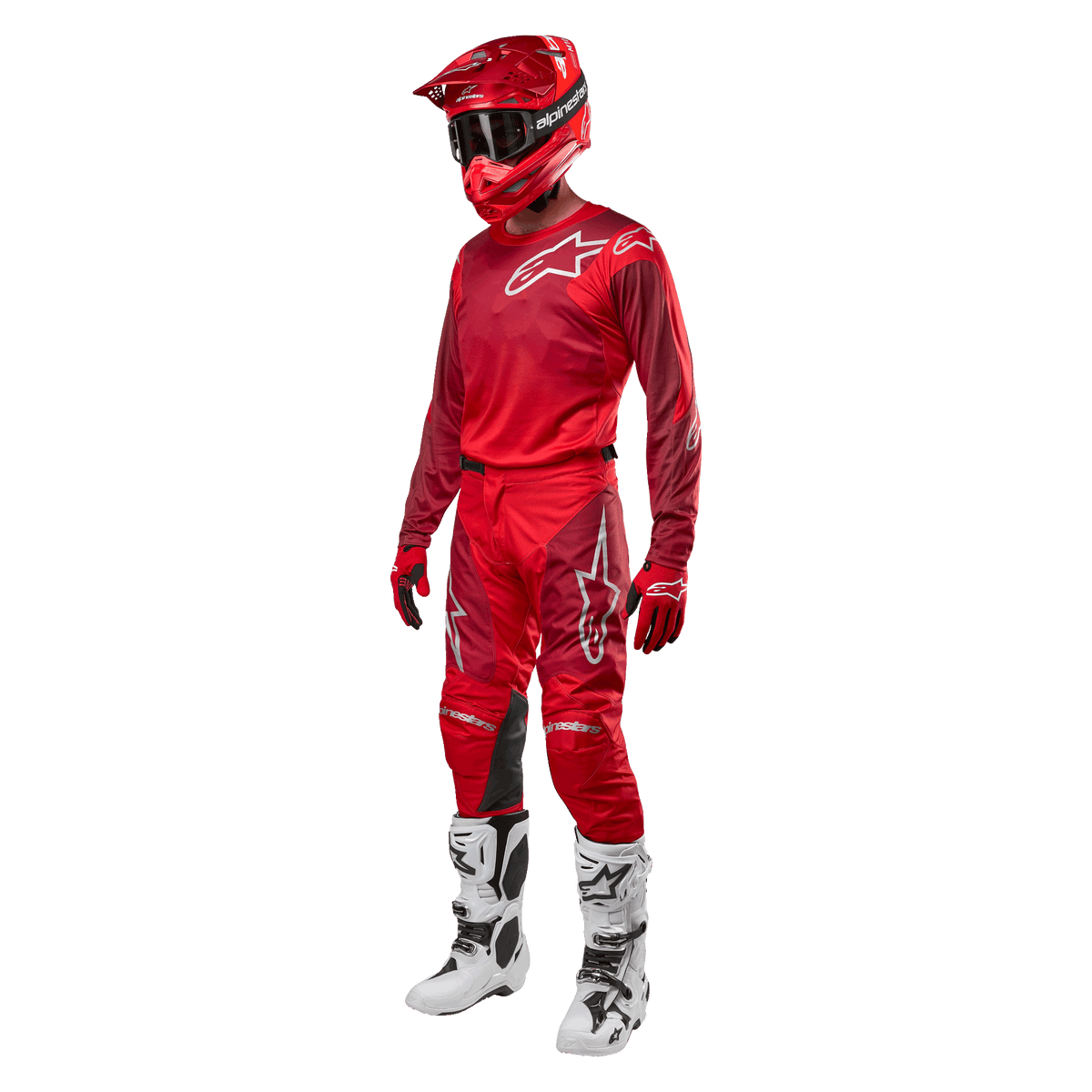 Motocross-kører iført komplet racerudstyr, Alpinestars 2024 Racer Hoen bukser og trøje i Mars Red Burgundy, rød hjelm, røde handsker og hvide og sorte støvler, koordineret outfit til terrænkørsel