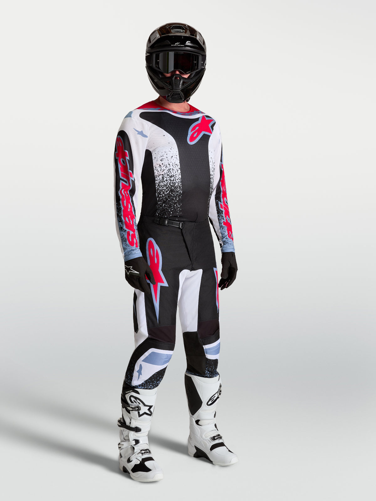 Alpinestars Fluid Drag bukser, motocross-racersæt til herrer i sort og hvid med røde fluo-detaljer.