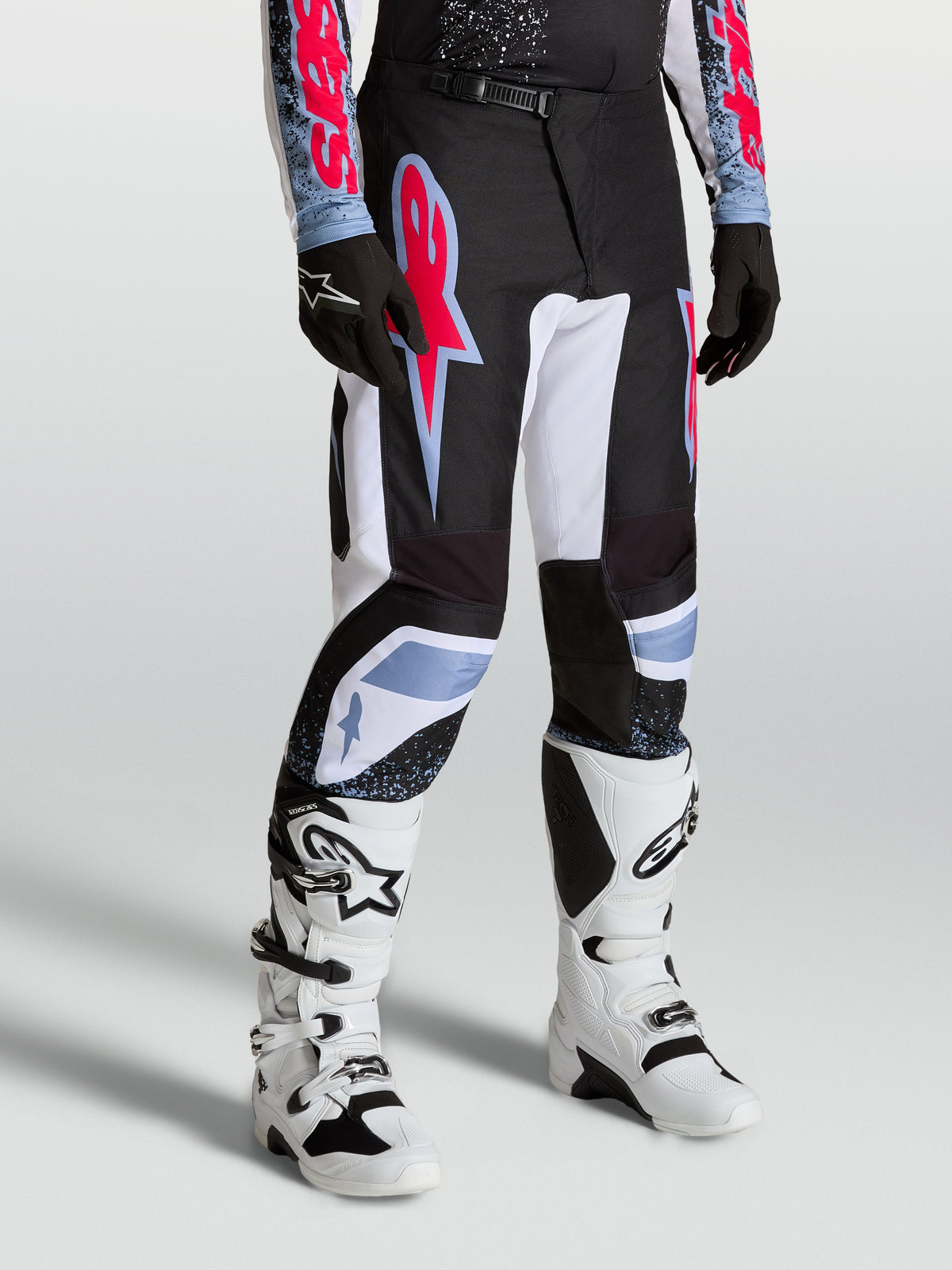 Alpinestars Fluid Drag Bukser, herre-motocrossbukser i sort og hvid med røde og lyseblå detaljer til motocross.