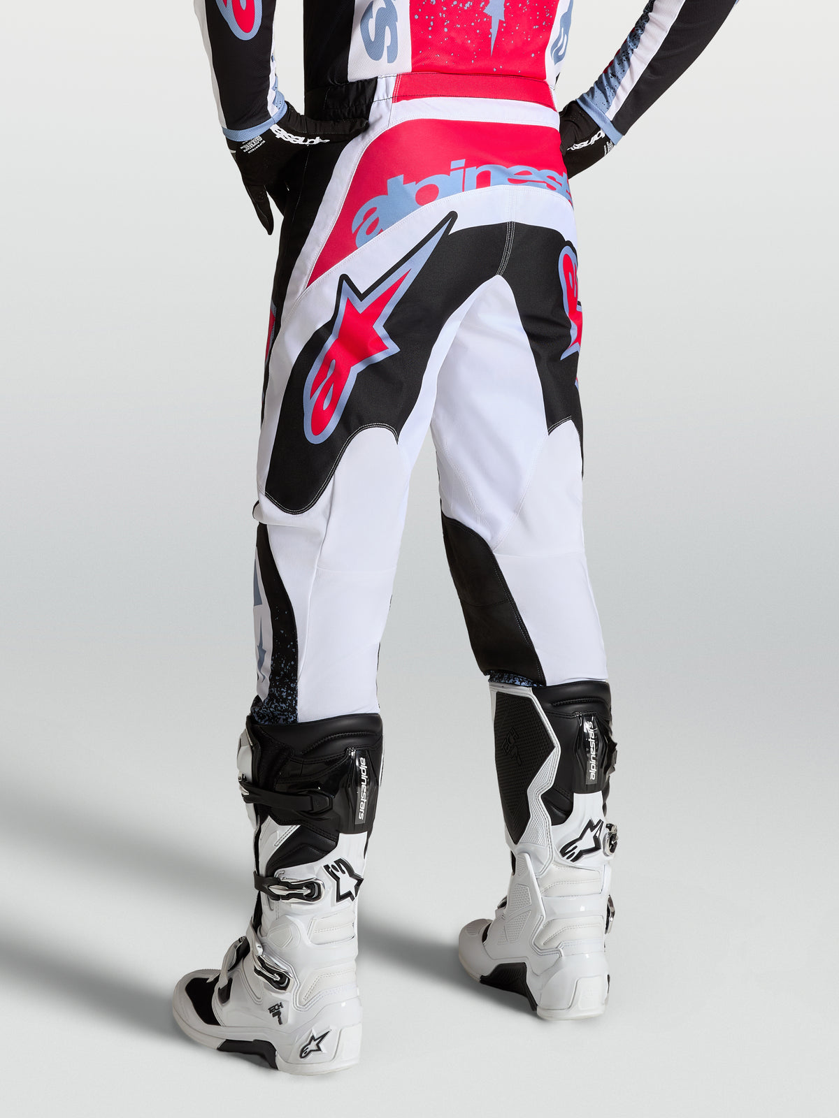 Alpinestars Fluid Drag Bukser, hvide og sorte motocrossbukser til herrer, set bagfra med røde og blå detaljer.