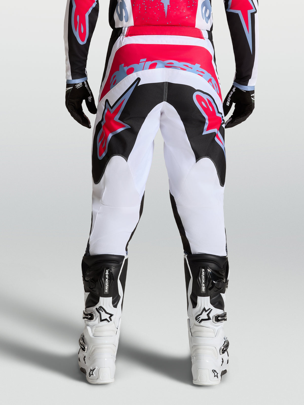 Alpinestars Fluid Drag bukser, herremotocrossbukser i hvid og sort med røde detaljer, set bagfra, slidstærkt 600D polyfabric.