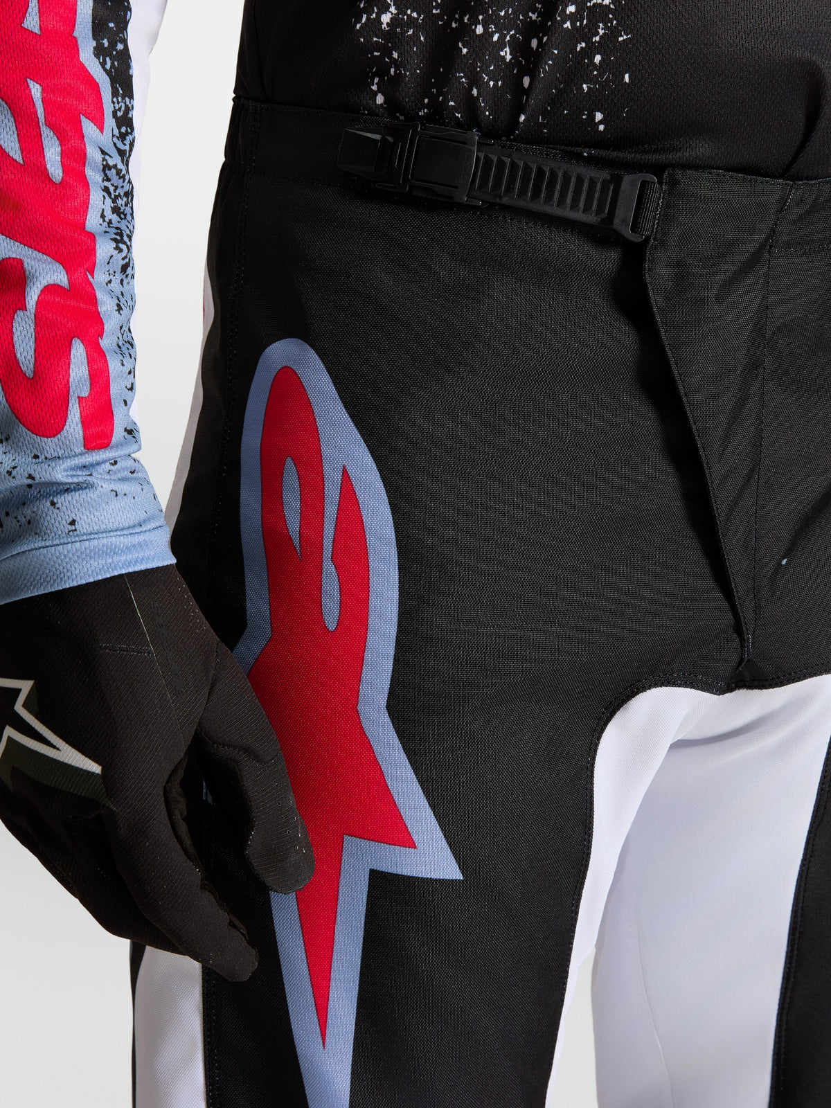 Alpinestars Fluid Drag bukser, sort og rød herre-motocrossbukser med skraldelukning og stort grafisk logo.