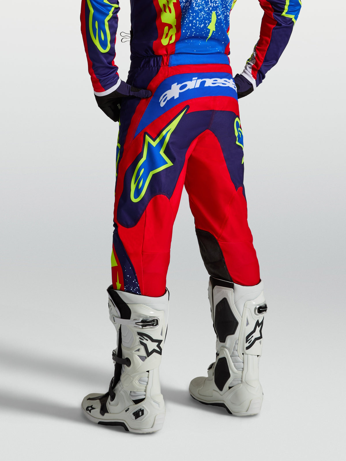 Alpinestars Fluid Drag bukser, mørkeblå og røde motocrossbukser til herrer med forstærket sæde og hvidt logo, set bagfra.