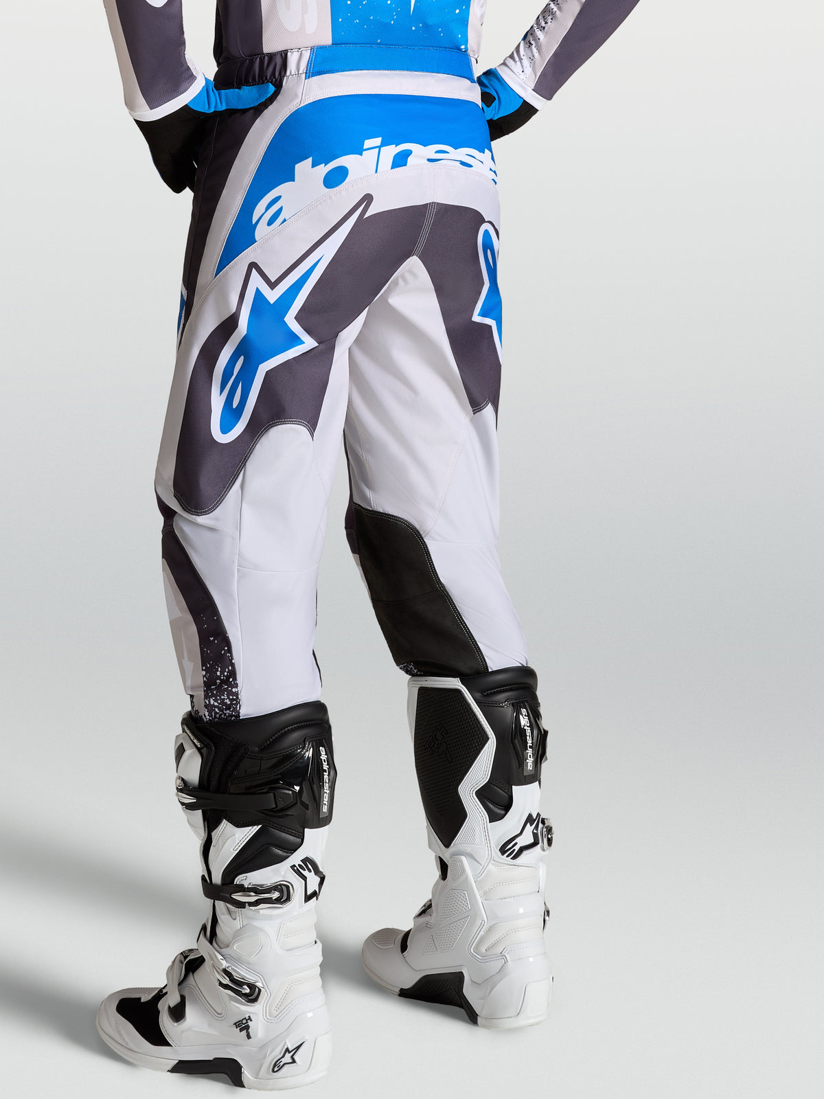 Alpinestars Fluid Drag Bukser i grå og blå, motocrossbukser set bagfra med ergonomisk 3D-mønsterkonstruktion.