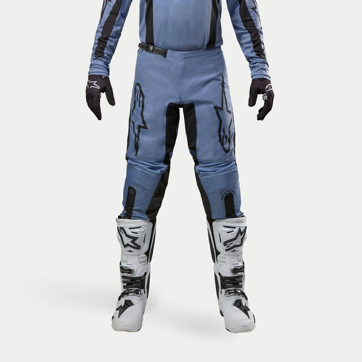 Alpinestars 2024 Fluid Lurv bukser, motocrossbukser, lyseblå og sort, vist med hvide og sorte racingstøvler og matchende handsker, med markante sorte stjernelogoer på lårene, ergonomisk design til off-road performance