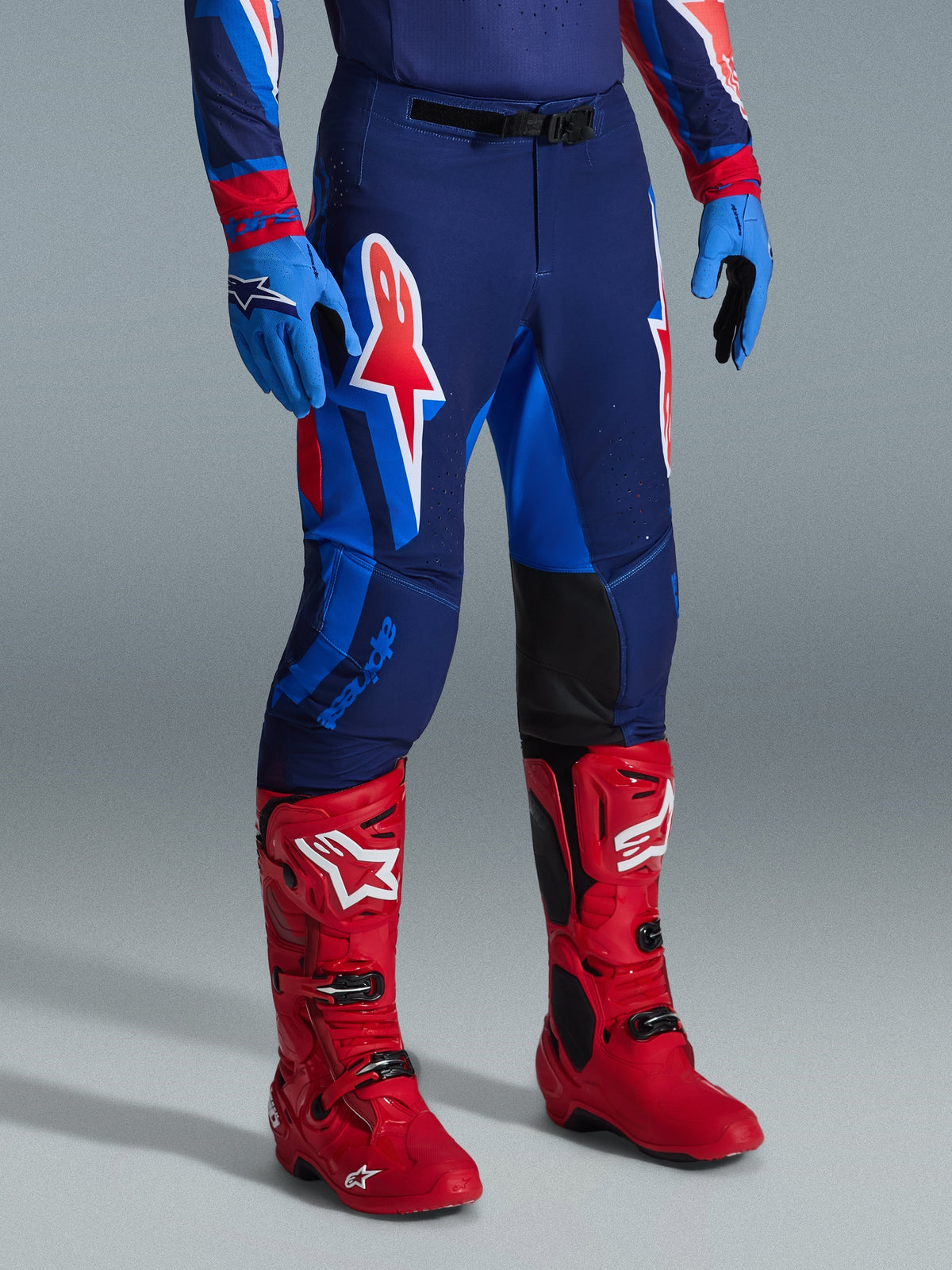 Alpinestars 2026 Supertech Vista udstyrssæt, motocrossbukser og støvler, mørkeblå med røde og lyseblå paneler, stort A-star logo på låret, klare røde racerstøvler, blå handsker, professionel atletisk race-pasform til motocross racing