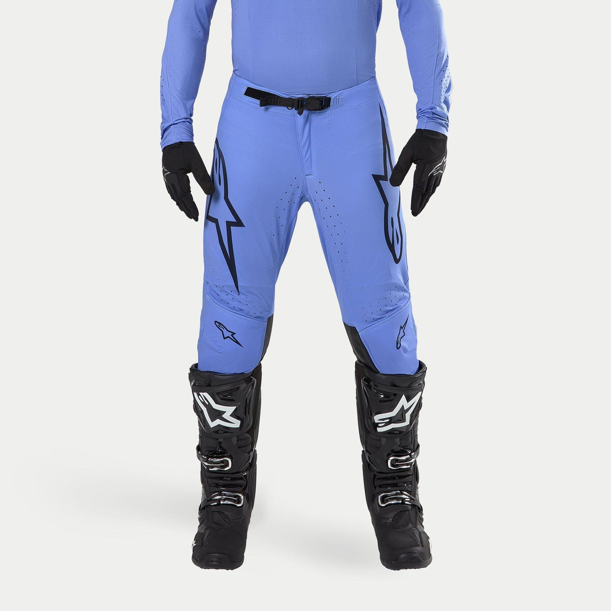 Alpinestars 2024 Supertech Dade bukser, motocross-bukser, lyseblå, med store sorte Astars-logoer på lårene, sort taljespænde, båret med sorte motocross-støvler og matchende blå overdel, professionelt terrænkørselsudstyr