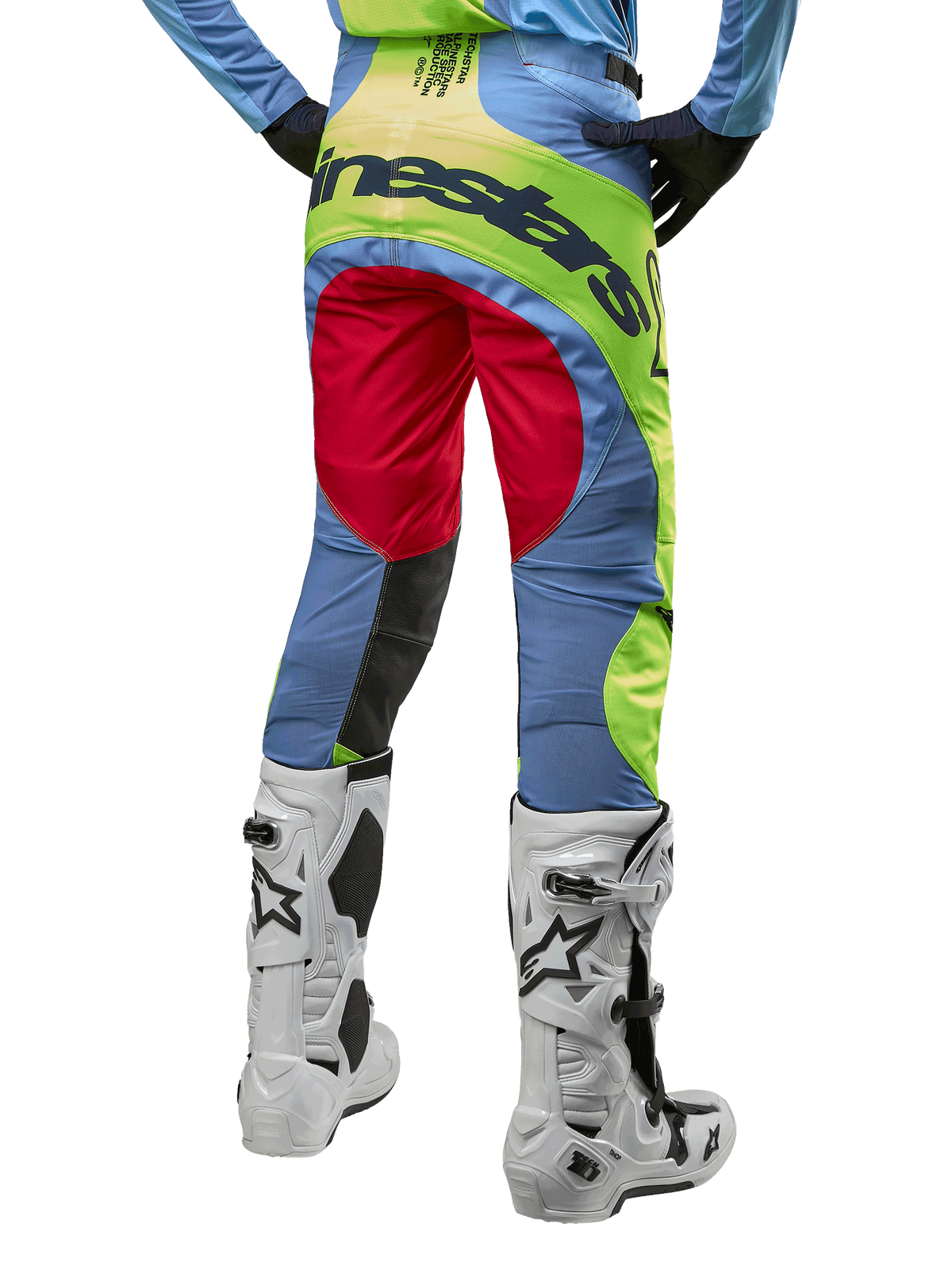 Alpinestars 2024 Techstar Ocuri bukser, motocrossbukser, lyseblå, fluoriserende gul og rød, set bagfra med hvide og sorte motocrossstøvler, markante farveblokke og Alpinestars-branding på bagdelen