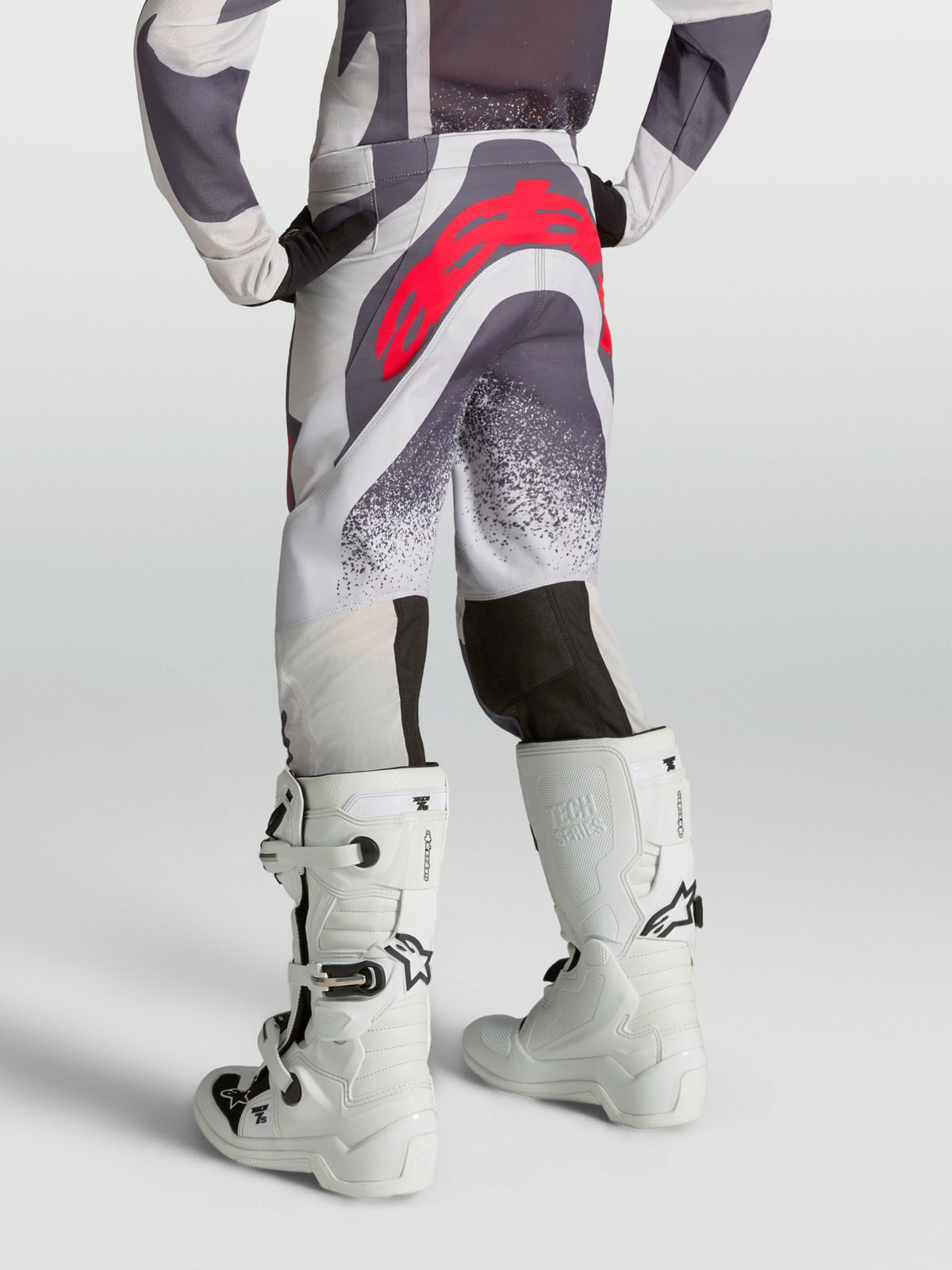 Alpinestars Supertech Swan bukser til ungdom, motocrossbukser i lys lilla og grå med rødt logo, set bagfra på model.