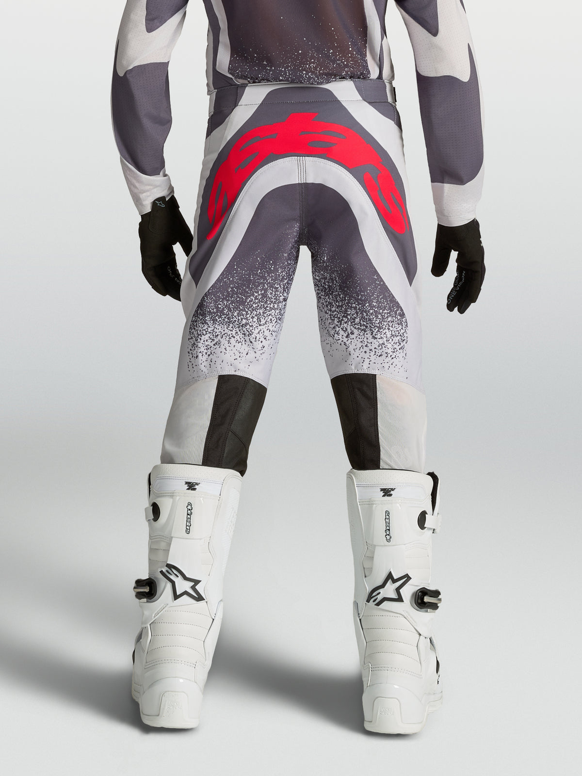 Alpinestars Supertech Swan motocrossbukser til unge, grå og rød, set bagfra med atletisk pasform og forstærket sæde.
