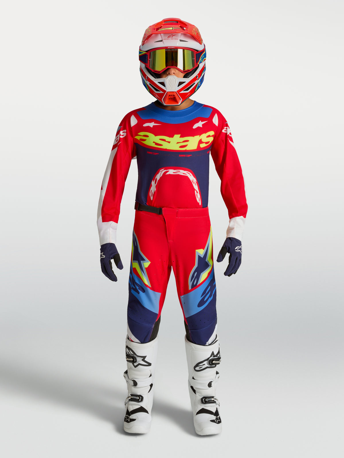 Alpinestars Supertech Dyna motocrosssæt til børn, rød og blå, komplet gear med trøje, bukser, hvide støvler og hjelm.