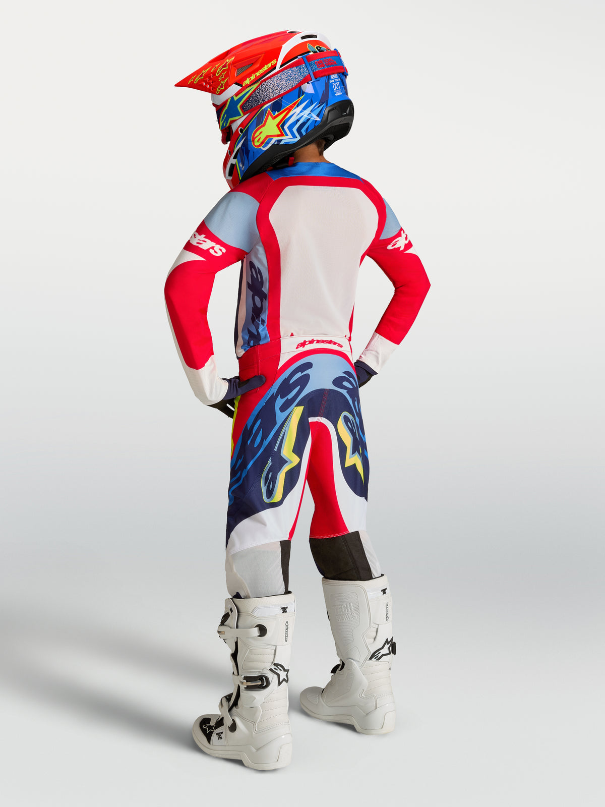Alpinestars 2027 Supertech Dyna bukser til unge, rødt og blåt motocrossudstyr med atletisk pasform, set bagfra.