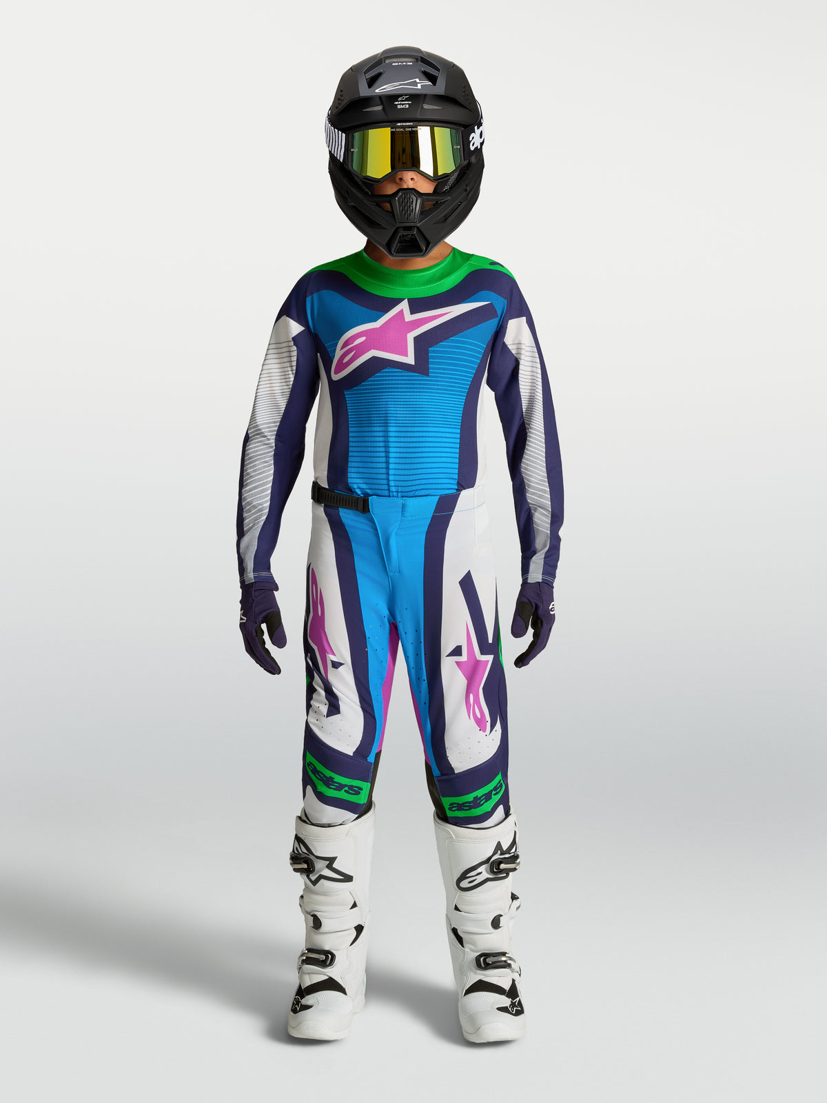 Alpinestars Supertech Maven bukser og trøje til ungdom, motocrossudstyr, blå og hvid med fluorescerende grønne detaljer, atletisk racerpasform, vist på model med hjelm og støvler
