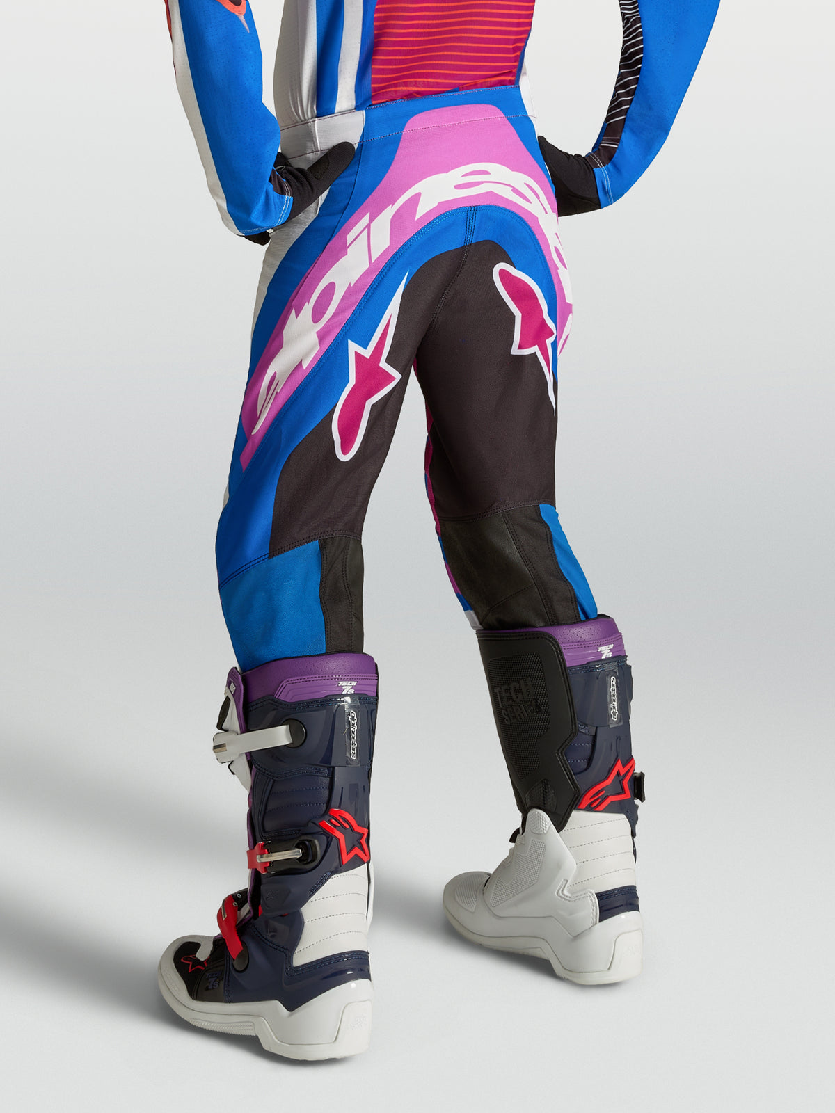 Alpinestars Supertech Maven bukser til ungdom, blå, pink og hvide motocrossbukser, atletisk pasform, set bagfra på rytter.