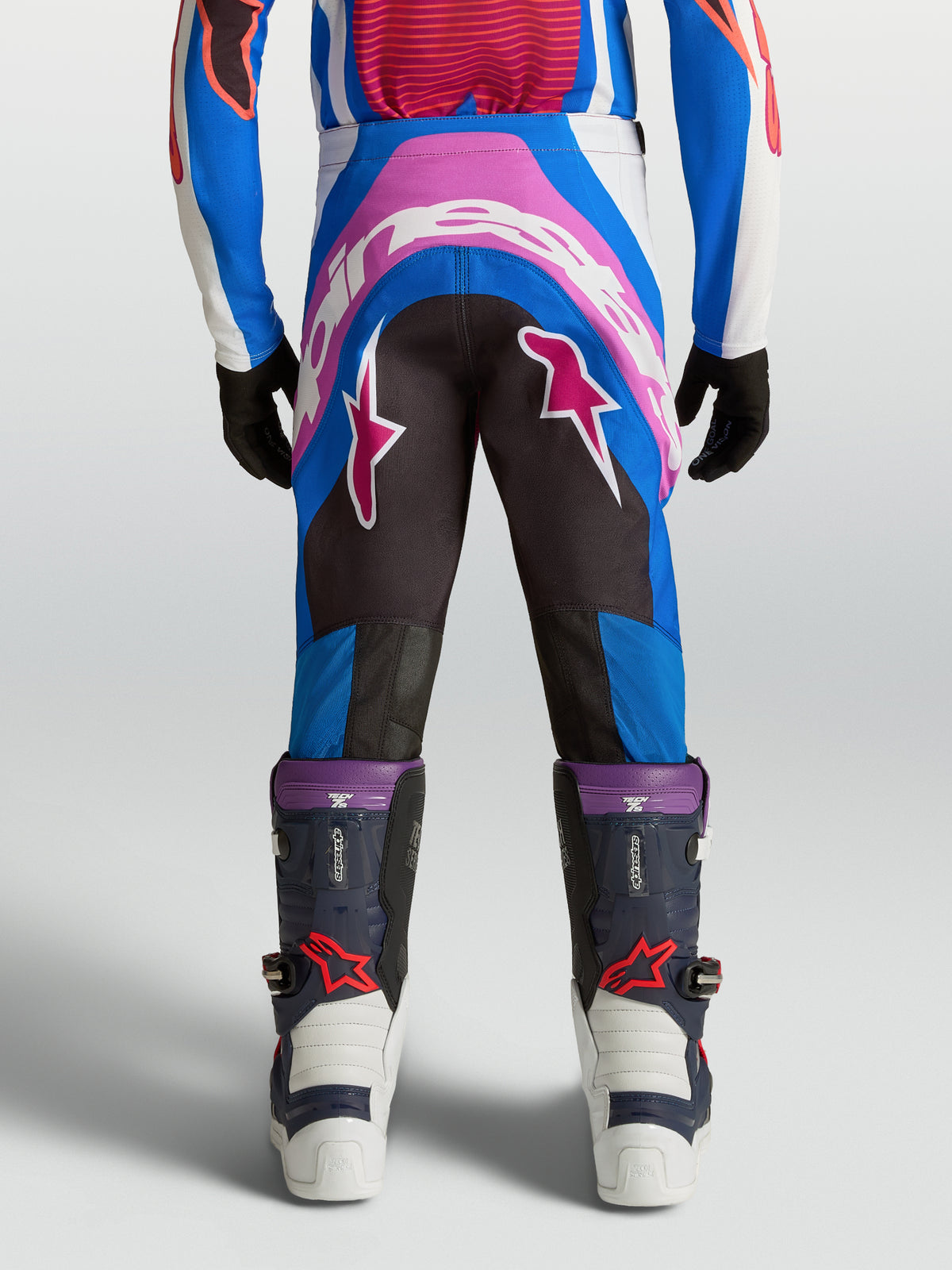 Alpinestars Supertech Maven motocrossbukser til ungdom i blå og hot coral, set bagfra med forstærket sæde og atletisk pasform