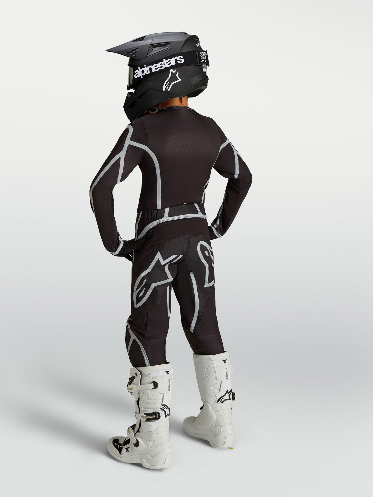 Alpinestars Youth Fluid Apex V2 Pants in Black and Silver, shown from the back as part of a full motocross racing kit.
