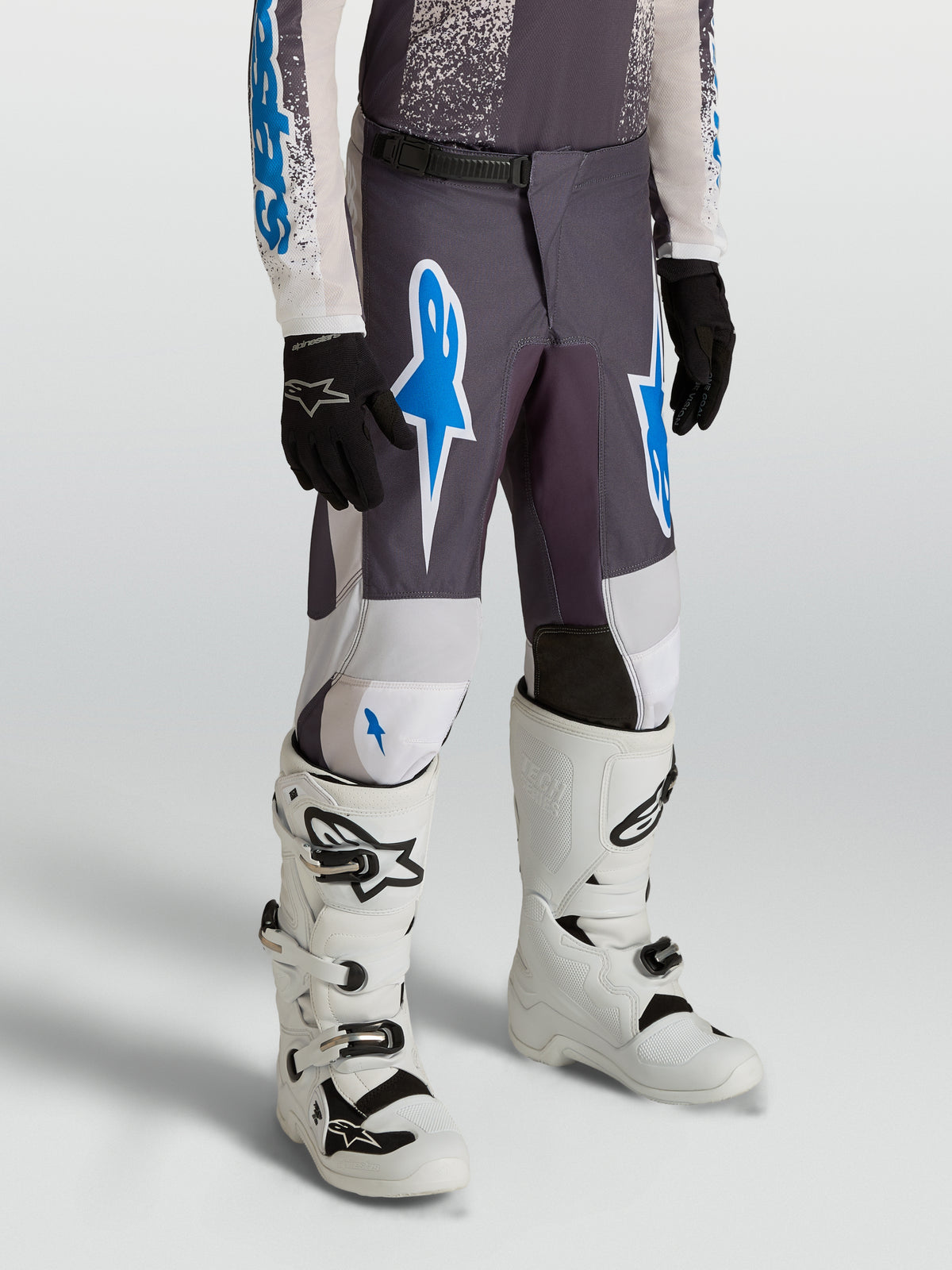 Alpinestars 2027 Fluid Drag bukser til ungdom, motocross- og off-road-bukser i grå og blå, slidstærkt 600D-polyfabric med ergonomisk pasform til terrænkørsel.