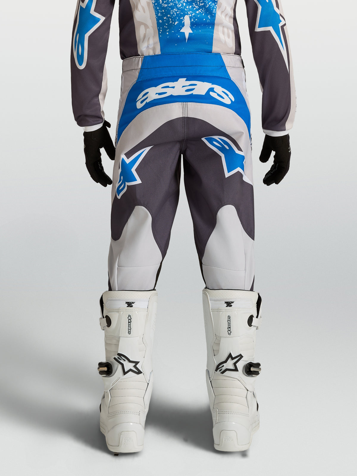 Alpinestars 2027 Fluid Drag bukser ungdom, grå og blå motocrossbukser med forbøjet pasform, set bagfra.