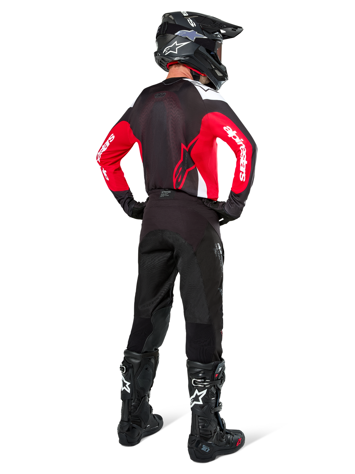 Motocrosskører set bagfra iført Alpinestars Pro-Dura trøje i sort, kraftig rød og hvid, kombineret med sorte motocrossbukser, hjelm og støvler, viser designet bagpå og logoer på ærmerne, koordineret off-road racerudstyr.