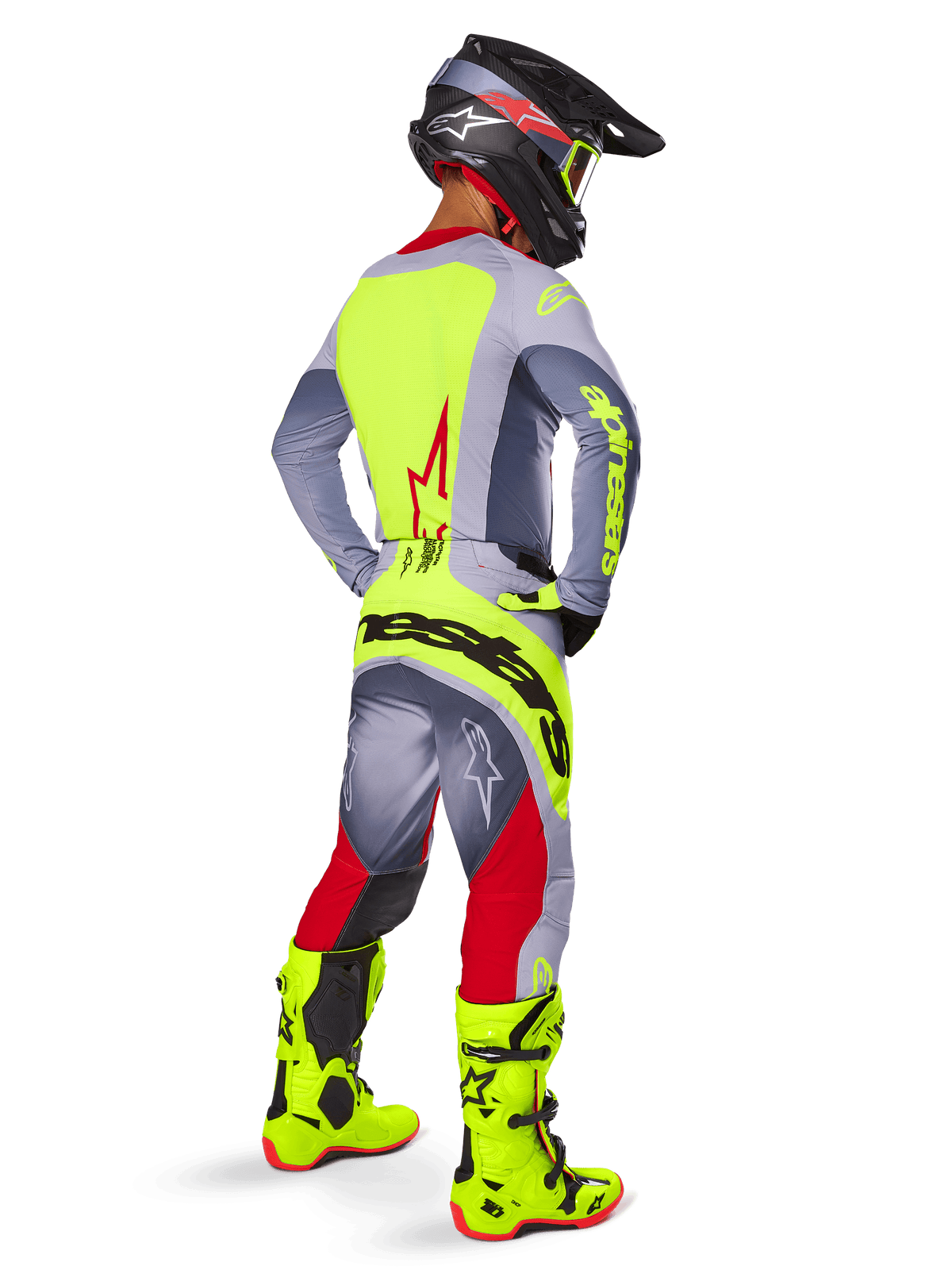 Motocrosskører set bagfra iført Alpinestars 2025 Techstar Melt trøje i Bright Red Gray, med et lysende gult rygpanel og grå ærmer, matchende grå og røde bukser med gult logo, lysende gule motocross-støvler og sort hjelm med gule goggles, koordineret off-road racingsæt