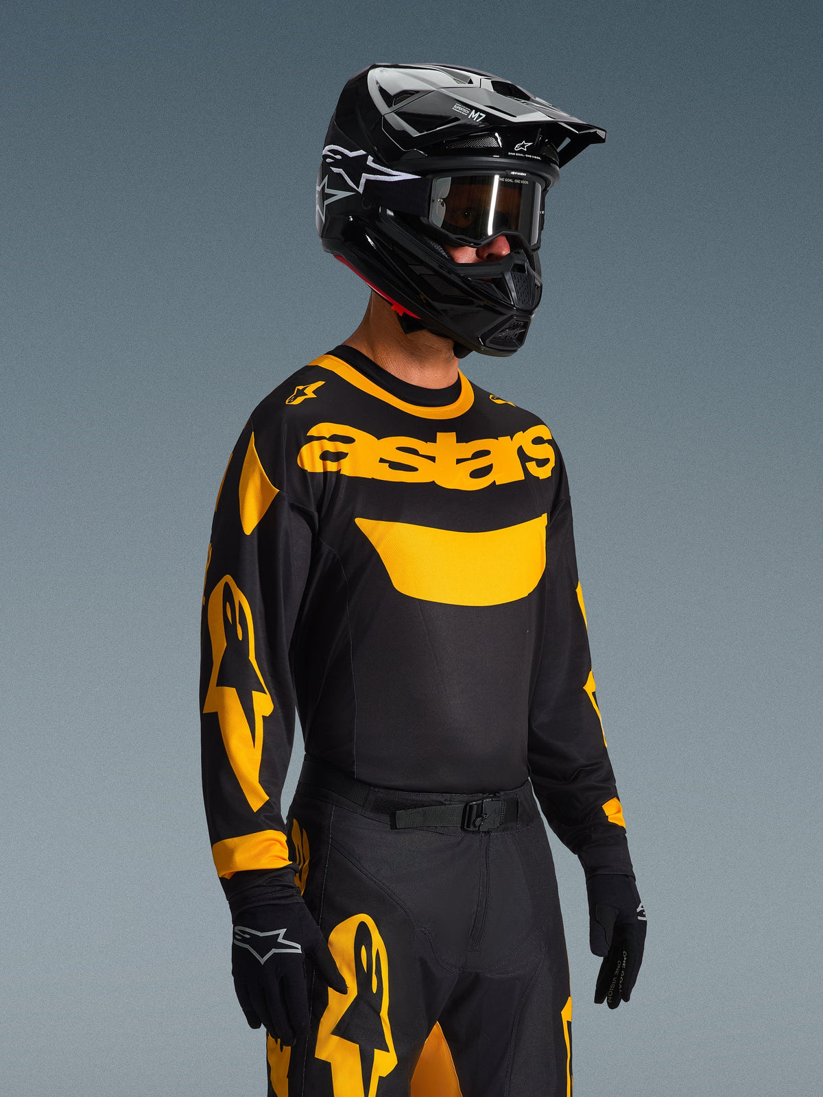 Motocross-kører iført Alpinestars 2026 Racer Riway Jersey i gul og sort, sort trøje med markant gul 'astars'-branding og grafik på ærmerne, matchende sorte og gule bukser, sort hjelm med briller og sorte handsker, professionelt off-road racerudstyr