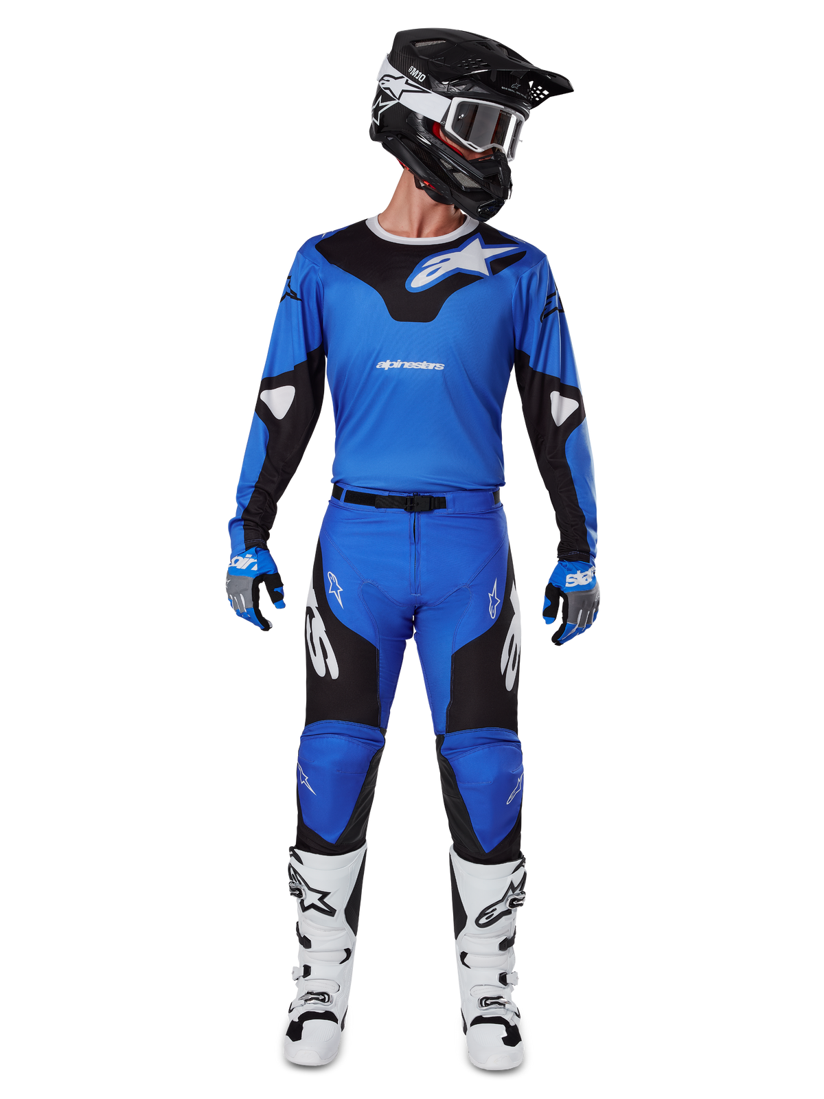 Motocrossrytter iført Alpinestars 2025 Racer Veil-udstyrssæt, blå og sort trøje med matchende bukser, sort hjelm med hvide goggles, hvide og sorte støvler, koordineret raceroutfit til off-road motocross.