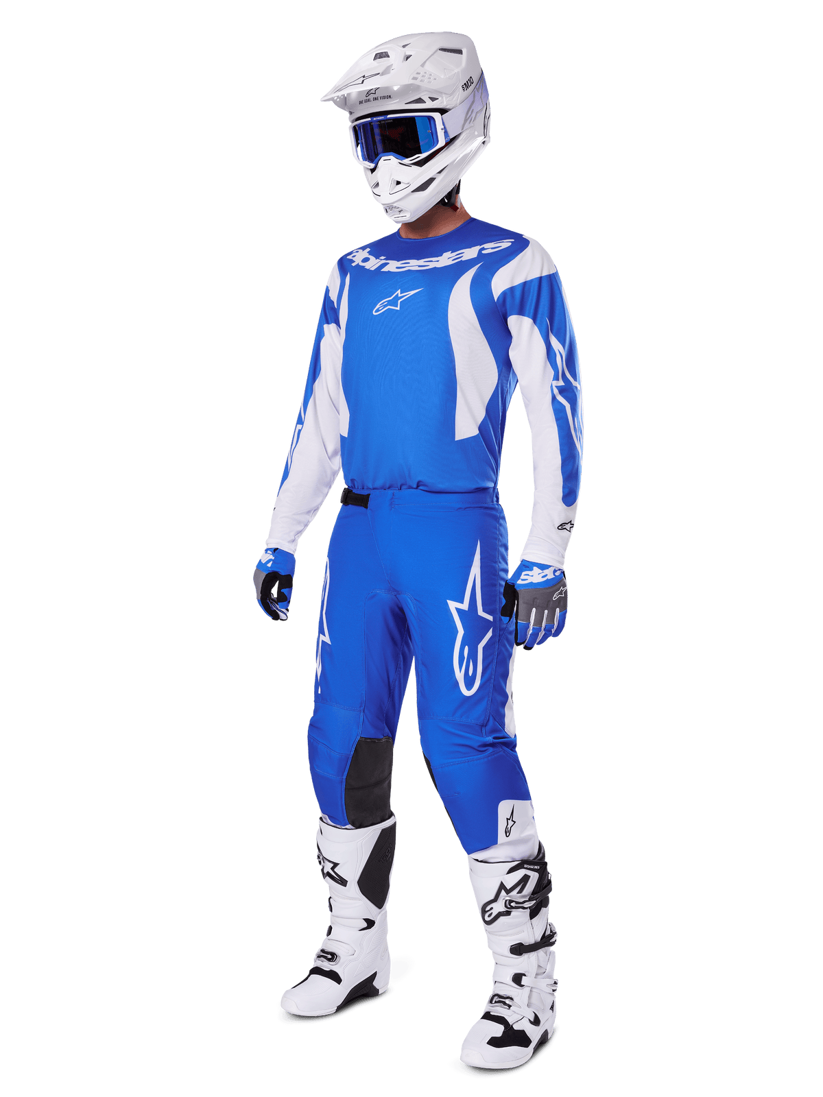 Motocross-rytter iført det komplette 2025 Fluid Haul Gear Set, blå og hvid trøje og bukser med Alpinestars-branding, hvid hjelm med blå goggles, hvide støvler og blå handsker, koordineret racersæt til off-road motocross.