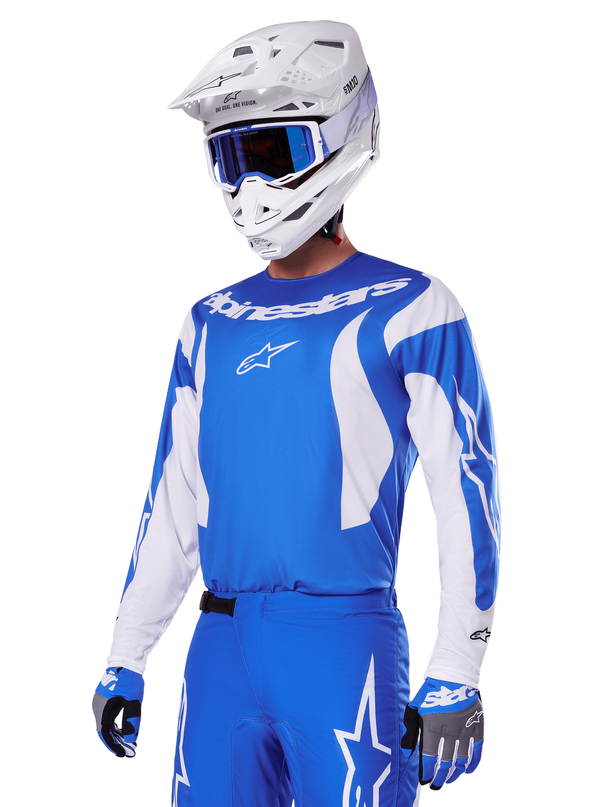 Motocross rider wearing the Alpinestars 2025 Fluid Haul Gear Set in Blue and White, featuring a blue jersey with white accents, matching blue pants with star logos, a white helmet with blue goggles, and coordinated blue and grey gloves, complete off-road racing outfit.
