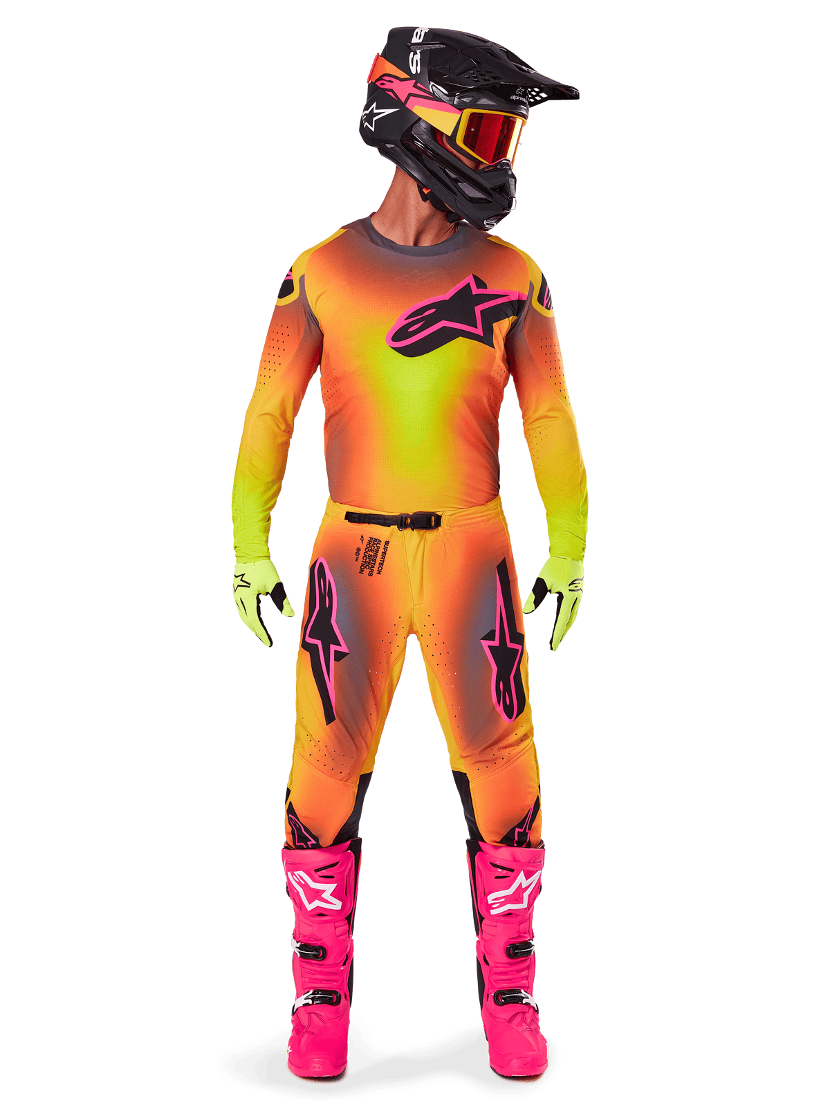 Motocross-kører iført komplet racerudstyr, 2025 Supertech Lipan trøje og bukser i en gul og orange gradient med lyserøde detaljer, sort hjelm med matchende lyserød grafik, pangfarvede lyserøde støvler og limegrønne handsker, koordineret Alpinestars off-road-raceroutfit.