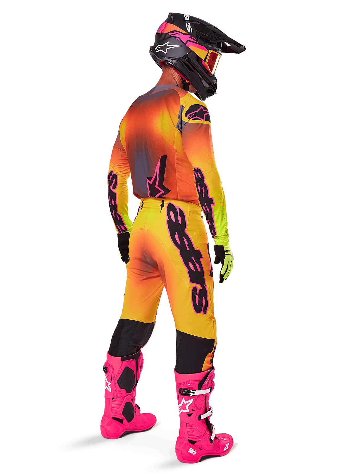 Motocrosskører set bagfra iført Alpinestars 2025 Supertech Lipan udstyrssæt, gul og orange trøje med farveovergang og lyserøde detaljer, matchende bukser, pang-lyserøde støvler og sort hjelm med lyserød og gul grafik, koordineret outfit til professionel racing