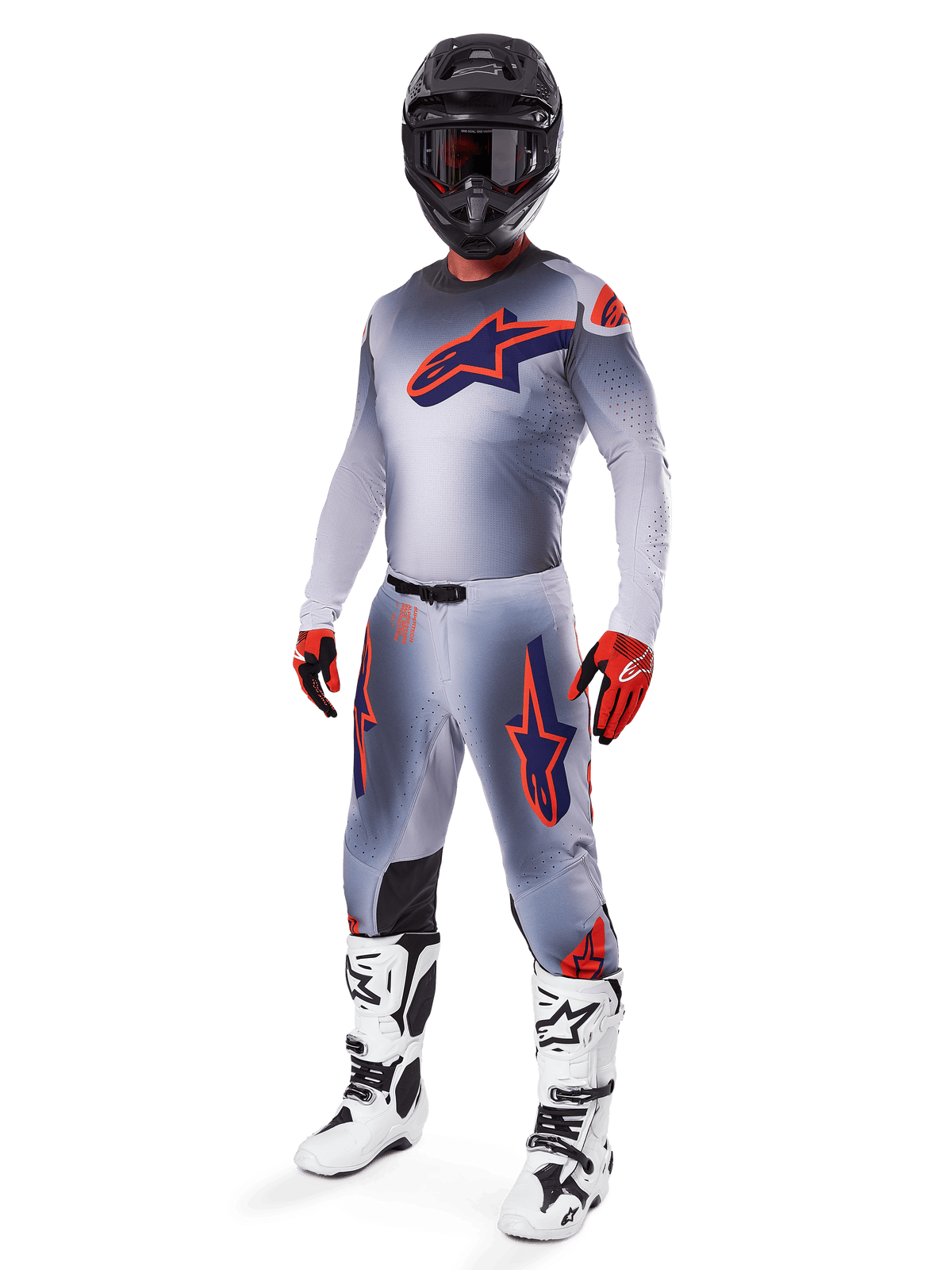 Motocrosskører iført Alpinestars 2025 Supertech Lipan Jersey i grå og orange fluo, matchende grå bukser med orange detaljer, sort hjelm, hvide og sorte støvler og orange og sorte handsker, professionelt udstyrssæt til terrænkørsel