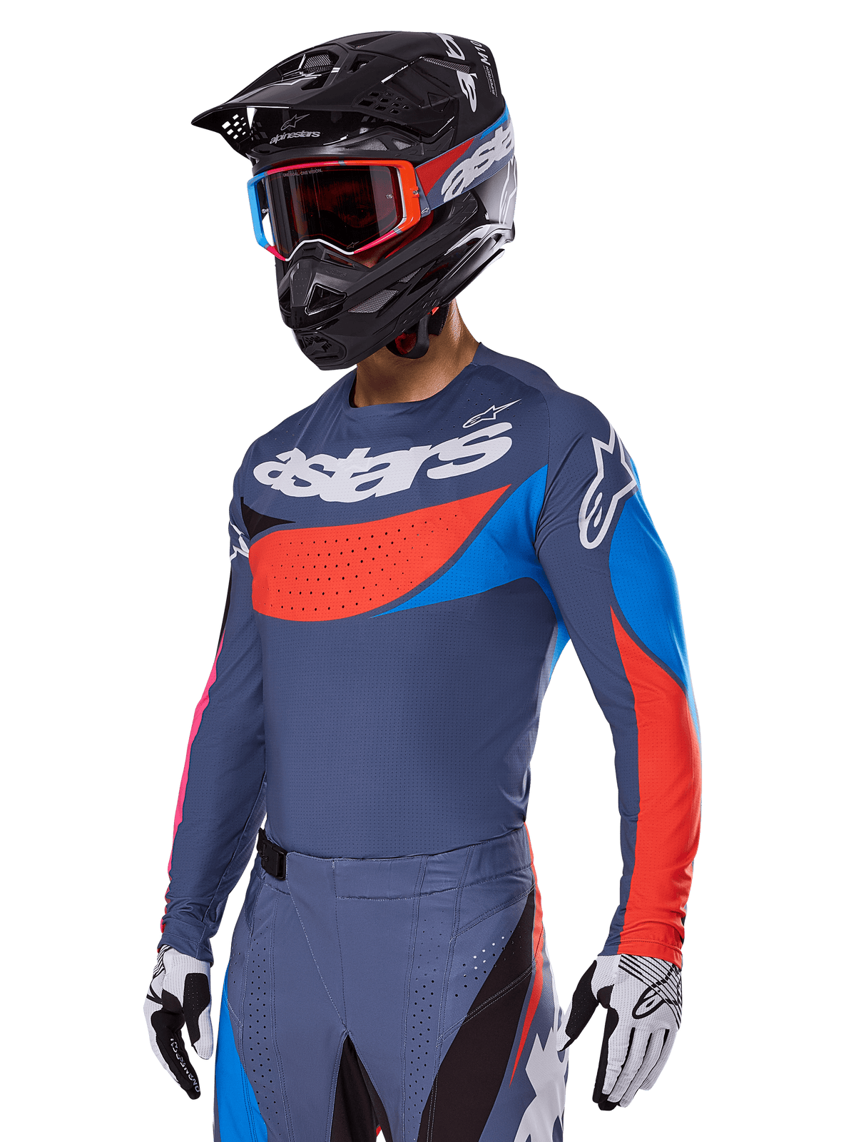 Alpinestars 2025 Techstar Dreem Gear Set, Motocross rider wearing slate gray jersey and pants with bold red and blue graphics, featuring 'astars' branding on the chest, paired with a black helmet, red-framed goggles, and white racing gloves