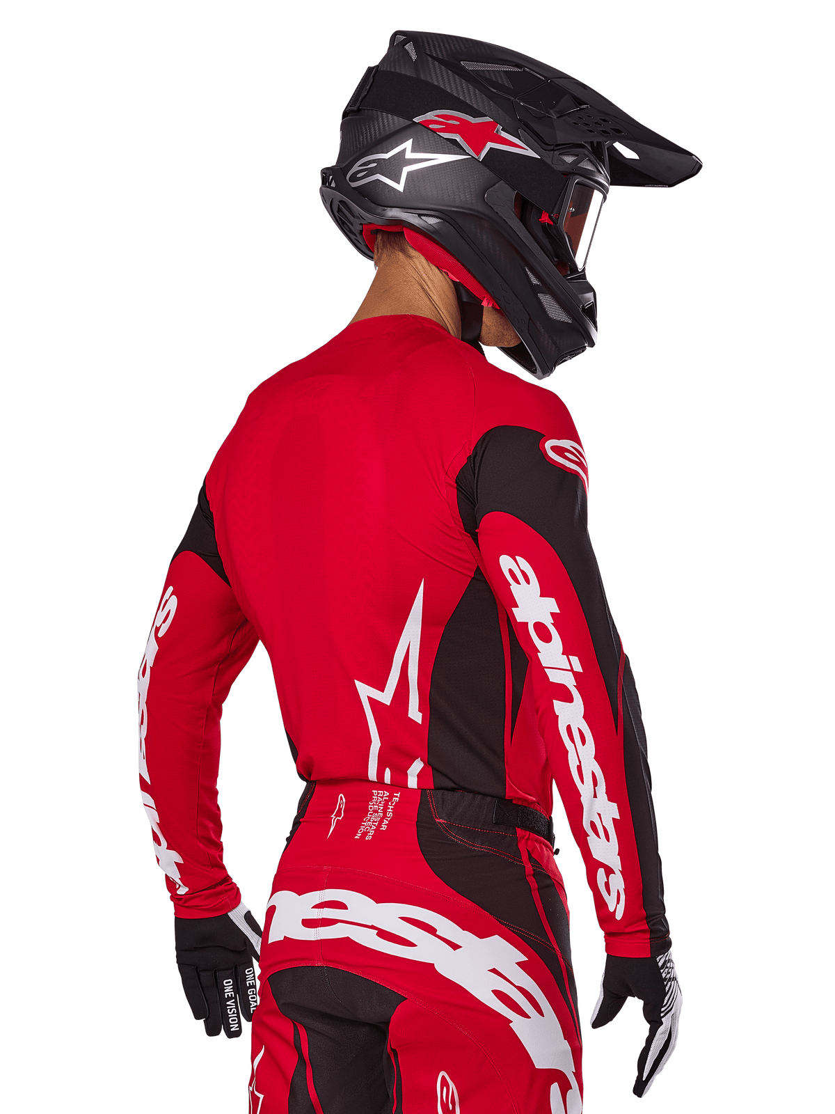 Motocross rider from back view wearing Alpinestars 2025 Techstar Dreem Gear Set, Red and black jersey with white sleeve branding, matching red and black pants with bold white logo on the seat, black carbon helmet with red accents, black and white gloves, professional off-road racing outfit.