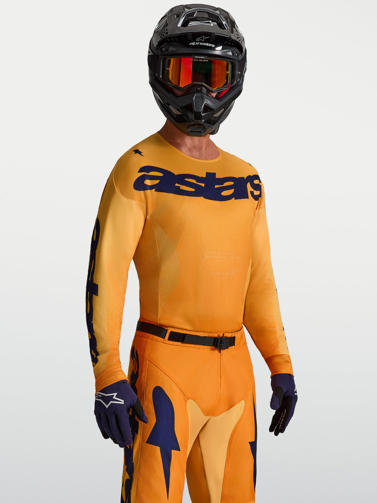 Alpinestars Racer Amber Jersey, orange gold and deep blue motocross top with moisture-wicking polyfabric on-model.