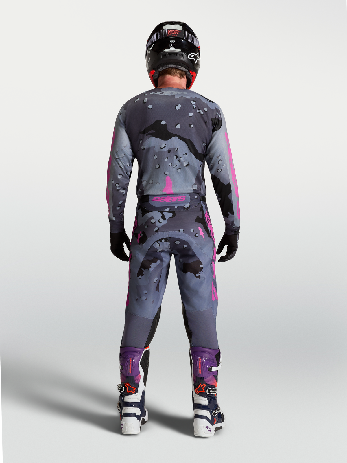Alpinestars Racer Lone gearsæt, grå og lilla camo motocross-outfit, set bagfra på rytter i matchende udstyr.