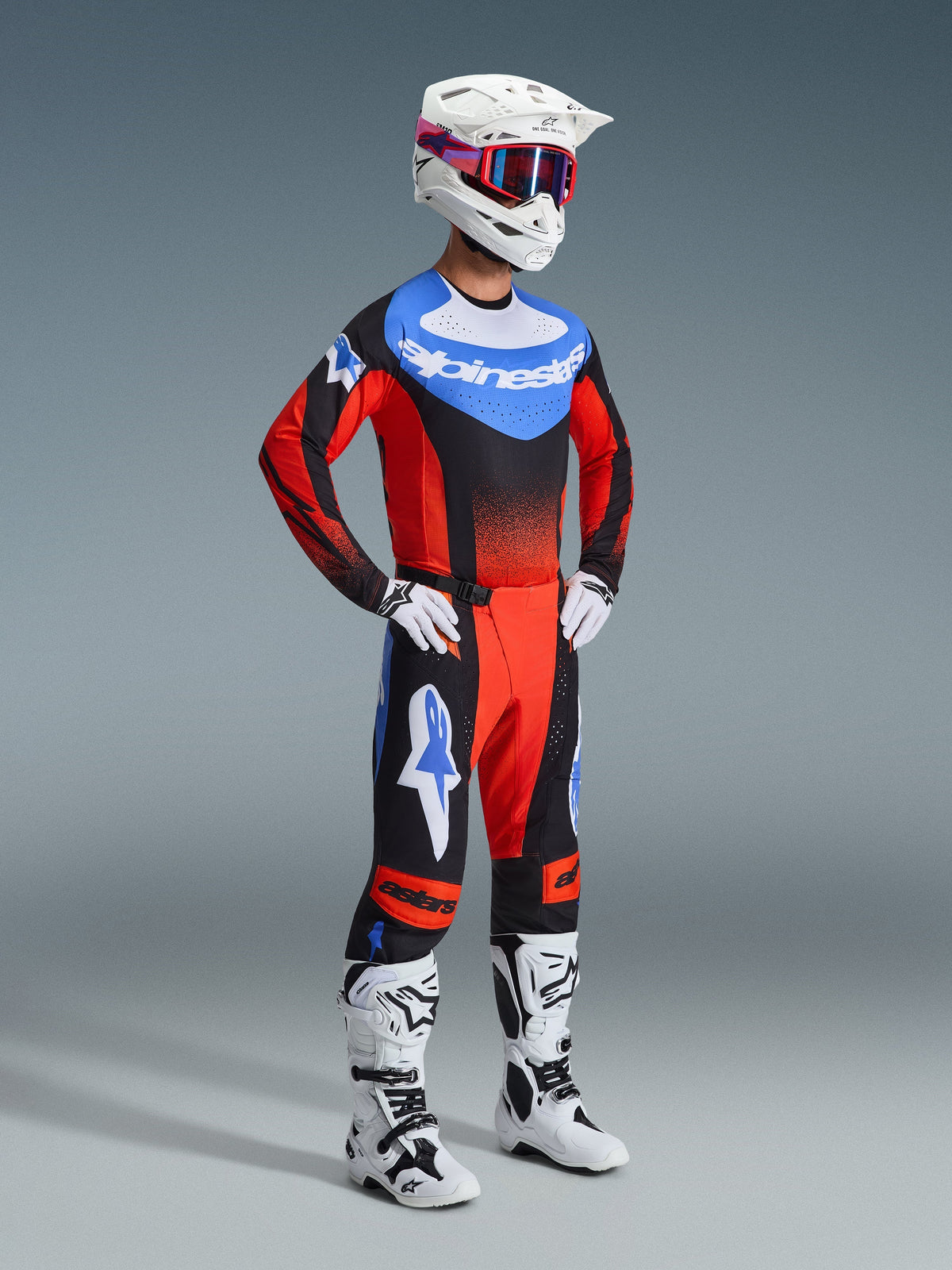 Motocross-kører iført 2026 Techstar Knif Jersey i orange, sort og UCLA Blue, kombineret med matchende motocross-bukser, hvid hjelm, hvide og sorte støvler og hvide handsker, koordineret professionelt racerudstyr til off-road konkurrence